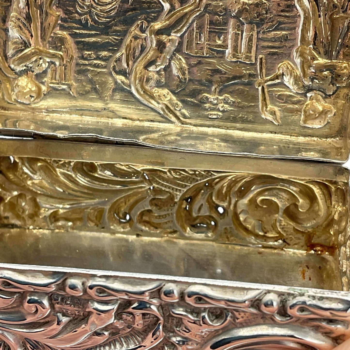 Close-up of intricately designed gold and silver box with detailed patterns.