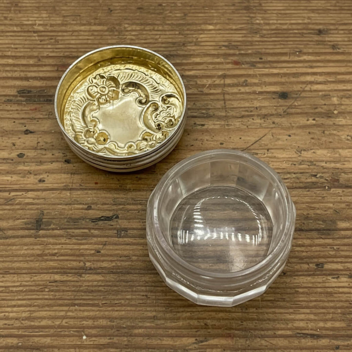 Gold lid and clear jar on a wooden surface