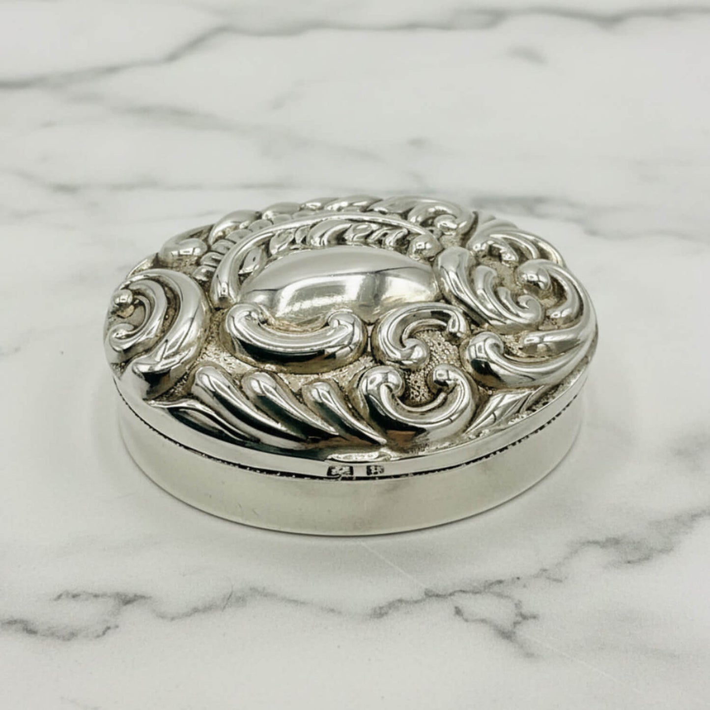 Antique 1901 Sterling Silver Pill Box on a marble surface
