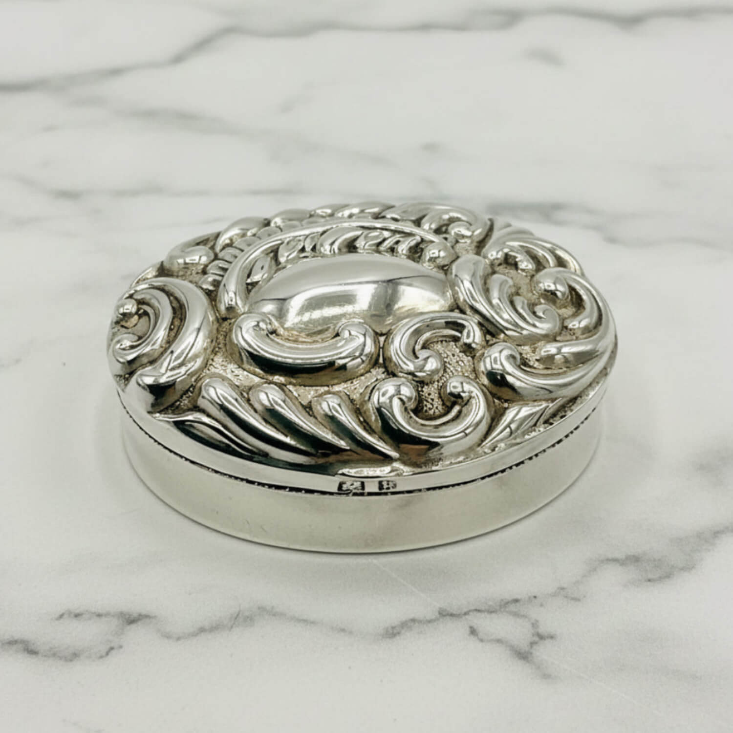 Antique 1901 Sterling Silver Pill Box on a marble surface
