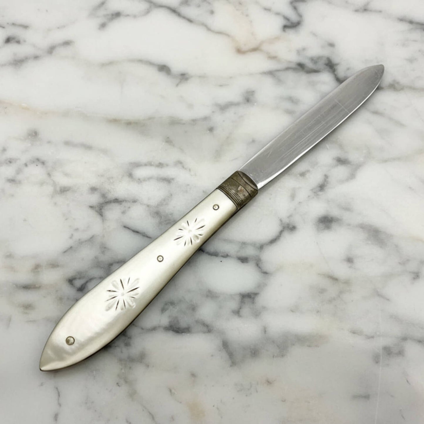 Decorative knife with engraved handle on a marble surface