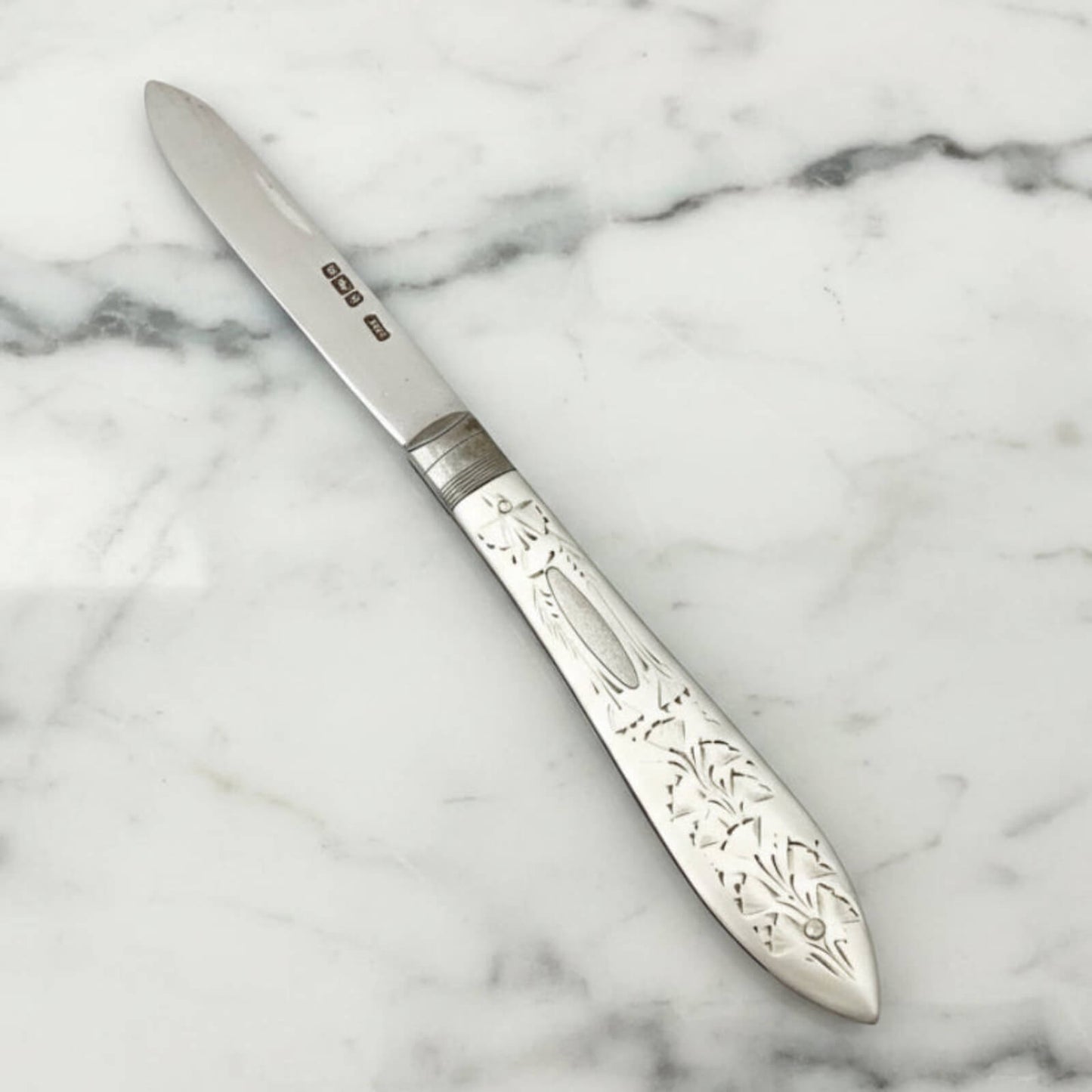 Decorative silver knife on a marble surface