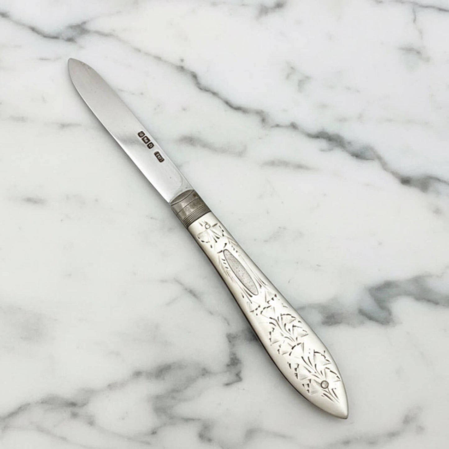 Decorative silver knife on a marble surface