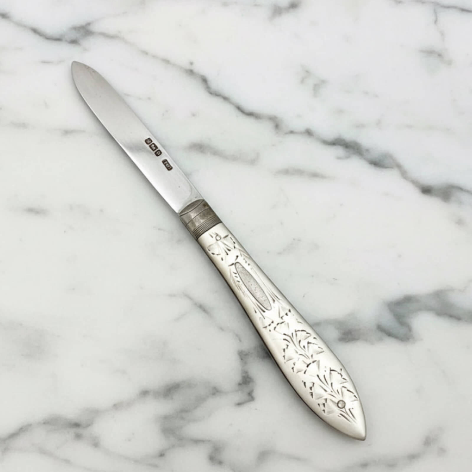 Decorative silver knife on a marble surface