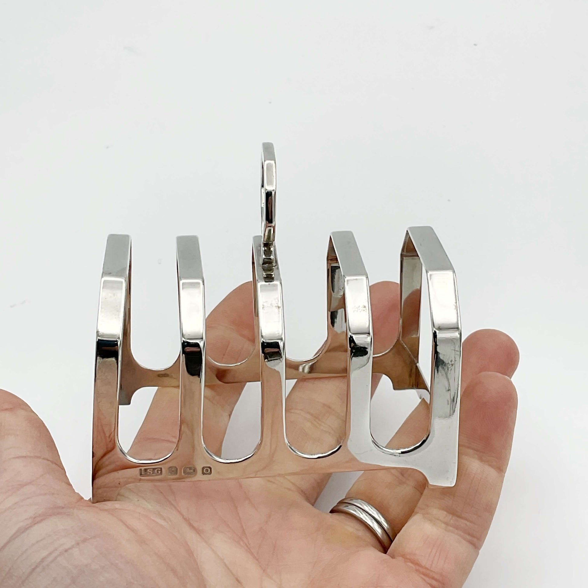 Antique Silver Toast rack held in a hand