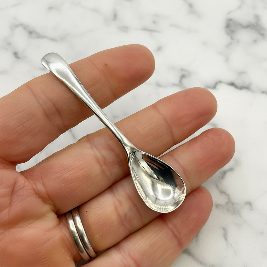 Antique 1920s Sterling Silver Salt Spoon in a hand
