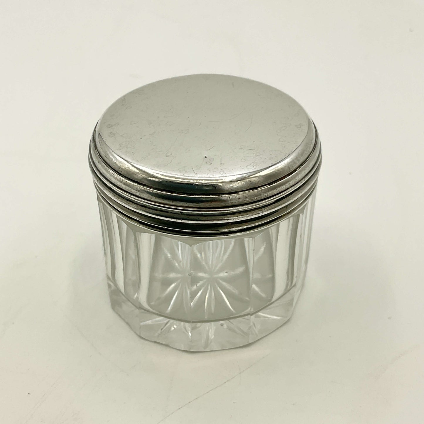 Clear glass jar with a silver lid on a white background