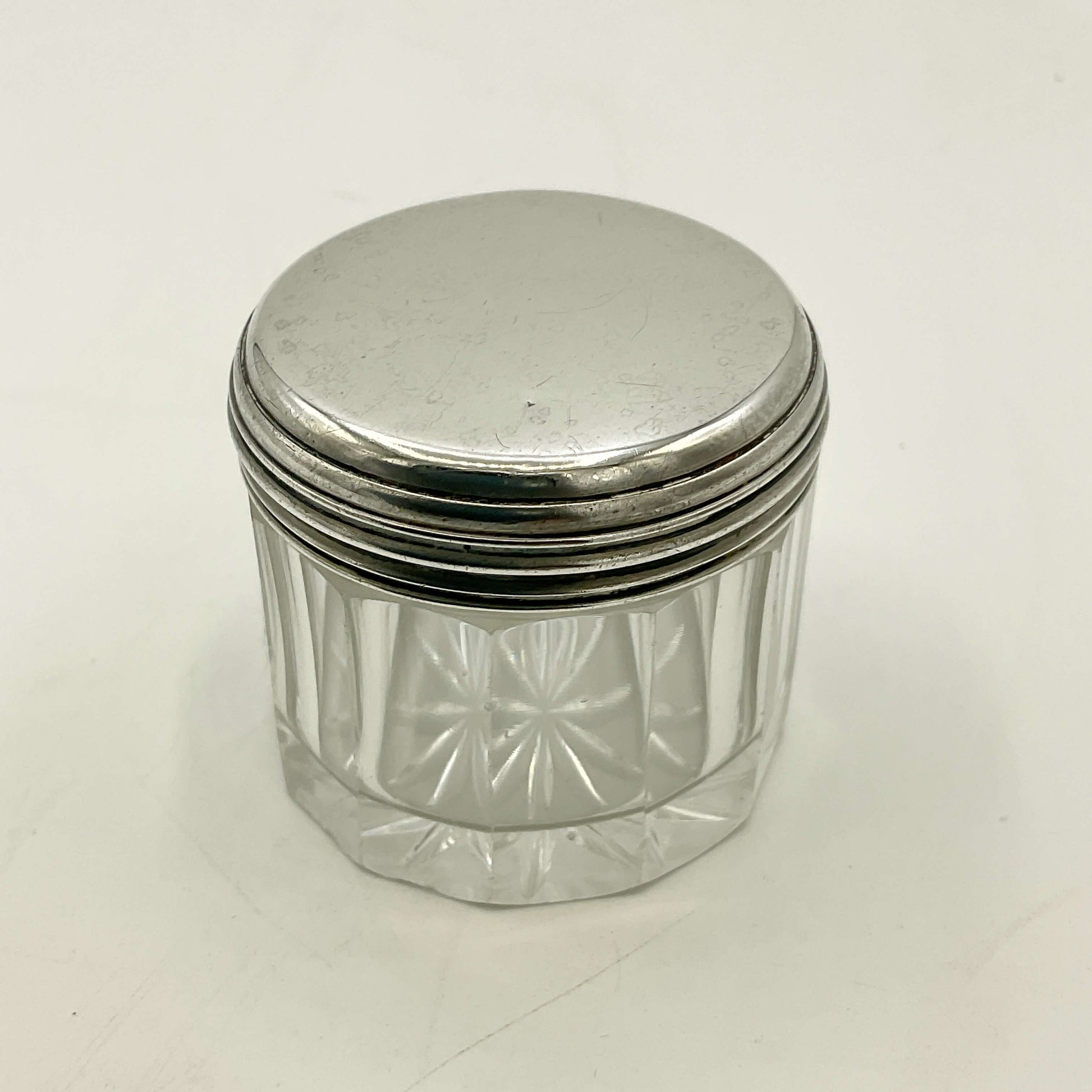 Clear glass jar with a silver lid on a white background