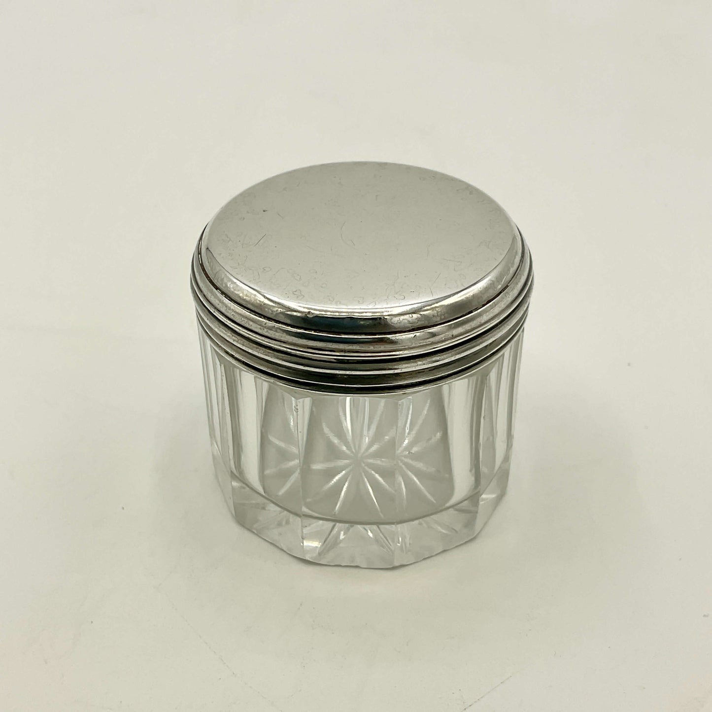 Clear glass jar with a silver lid on a white background