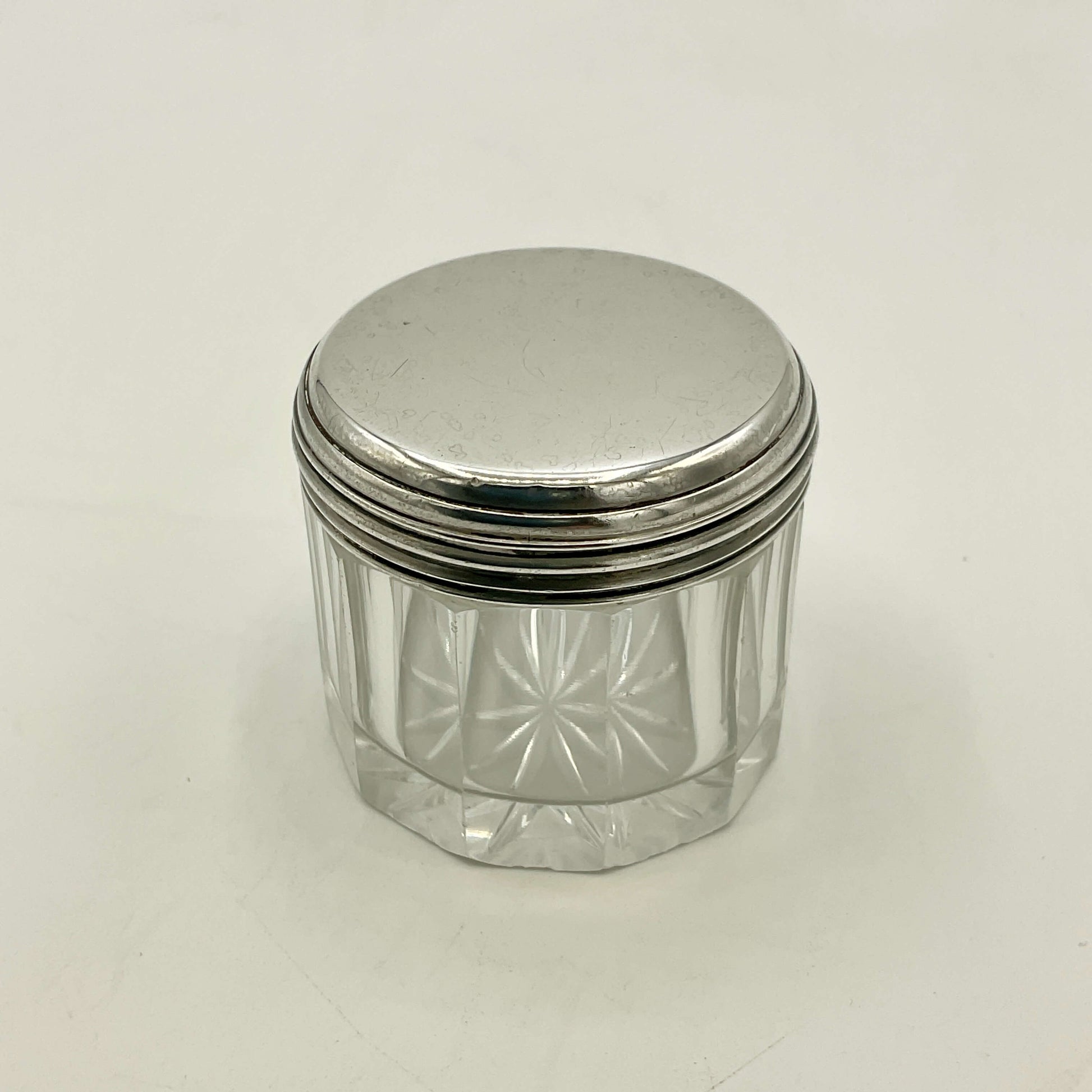 Clear glass jar with a silver lid on a white background