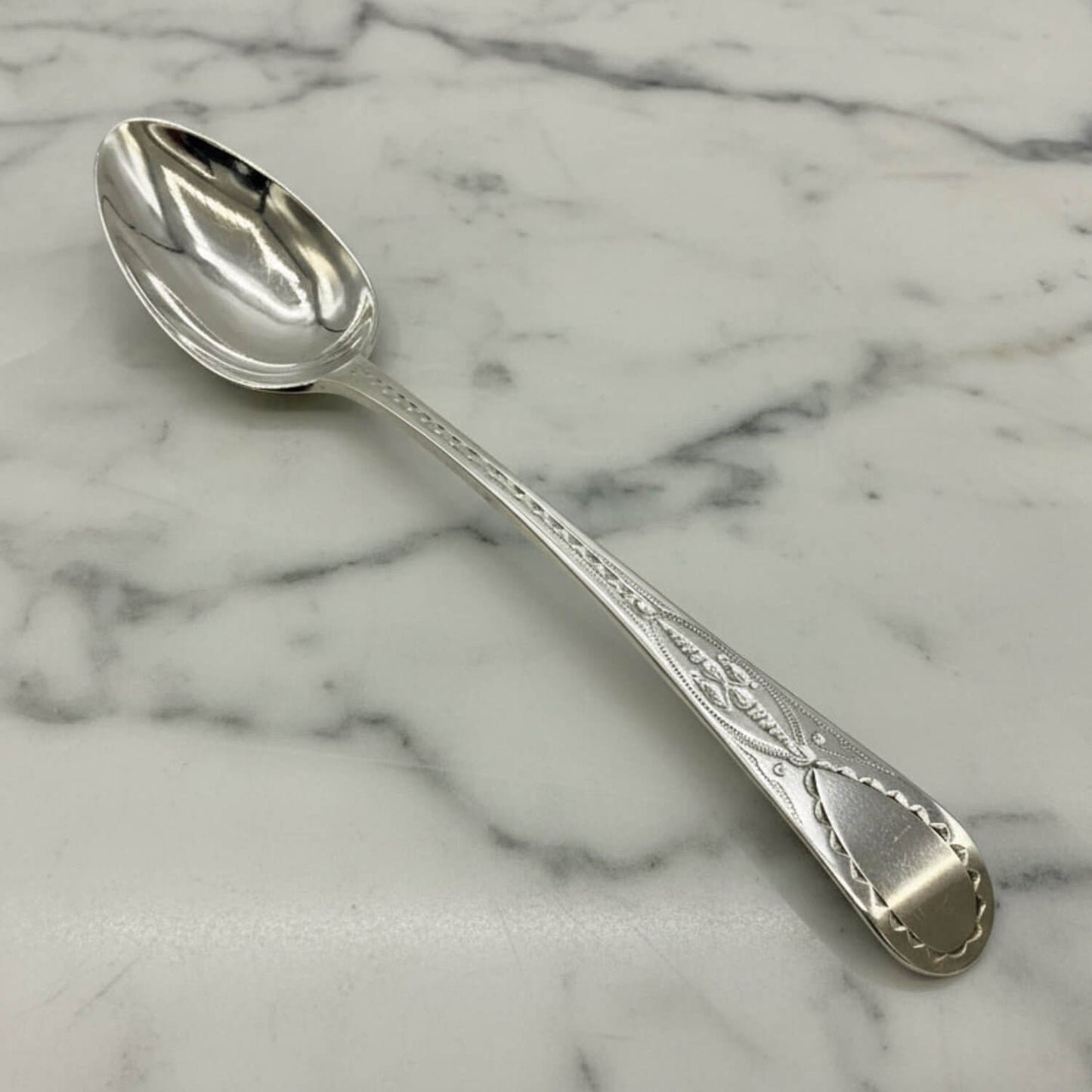 Antique Georgian Sterling Silver Teaspoon, Hallmarked 1793 on a marble surface