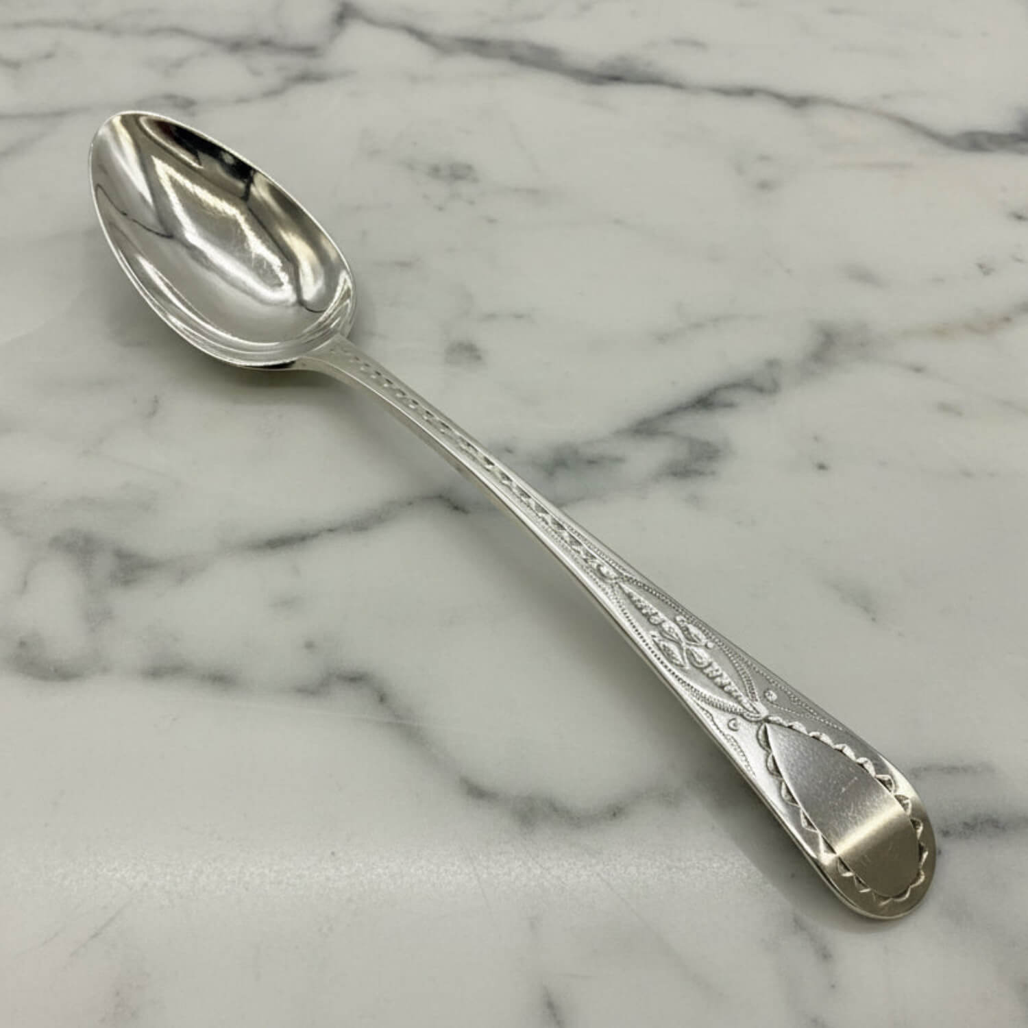 Antique Georgian Sterling Silver Teaspoon, Hallmarked 1793 on a marble surface