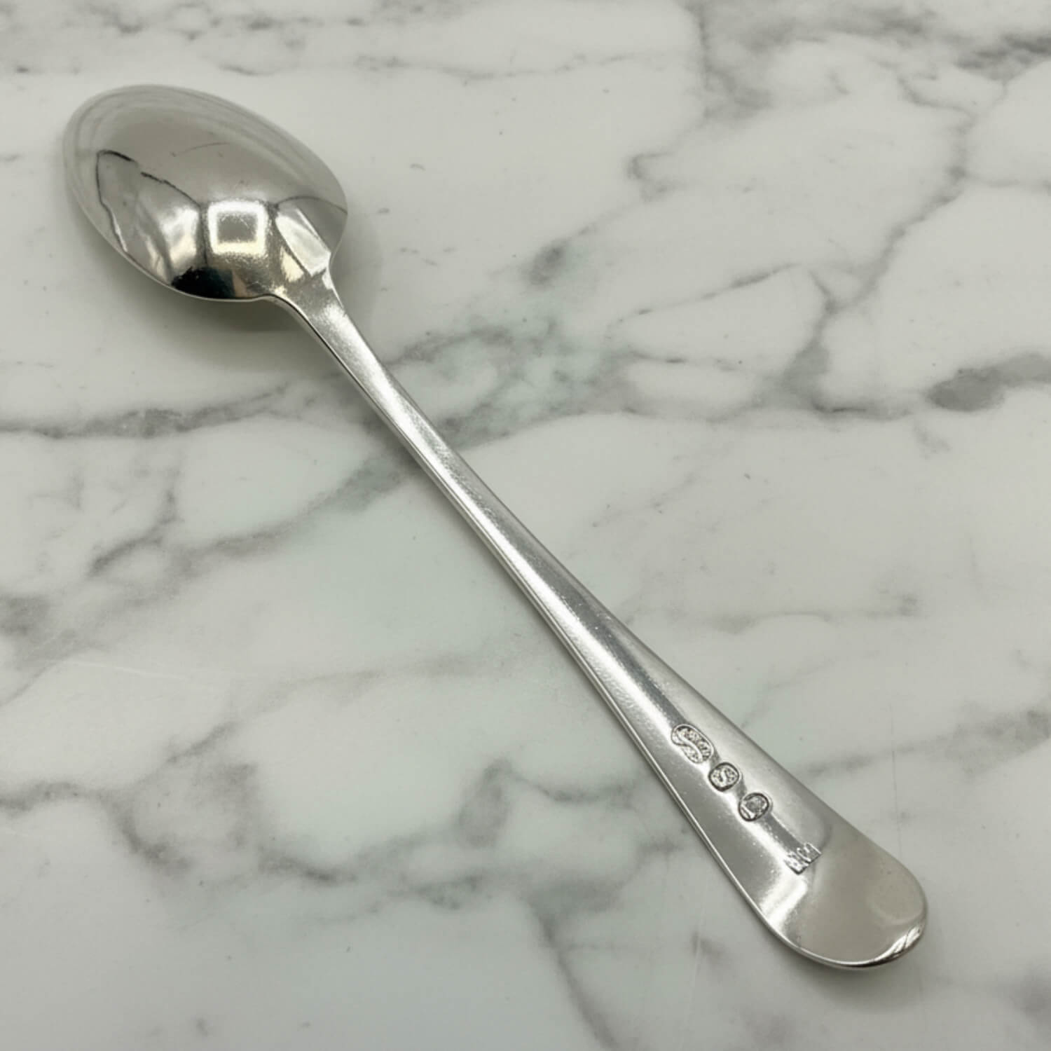 back of a Silver spoon on a marble surface