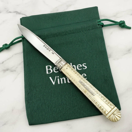 Decorative knife with gold handle on a green cloth with 'Beeches Vintage' text