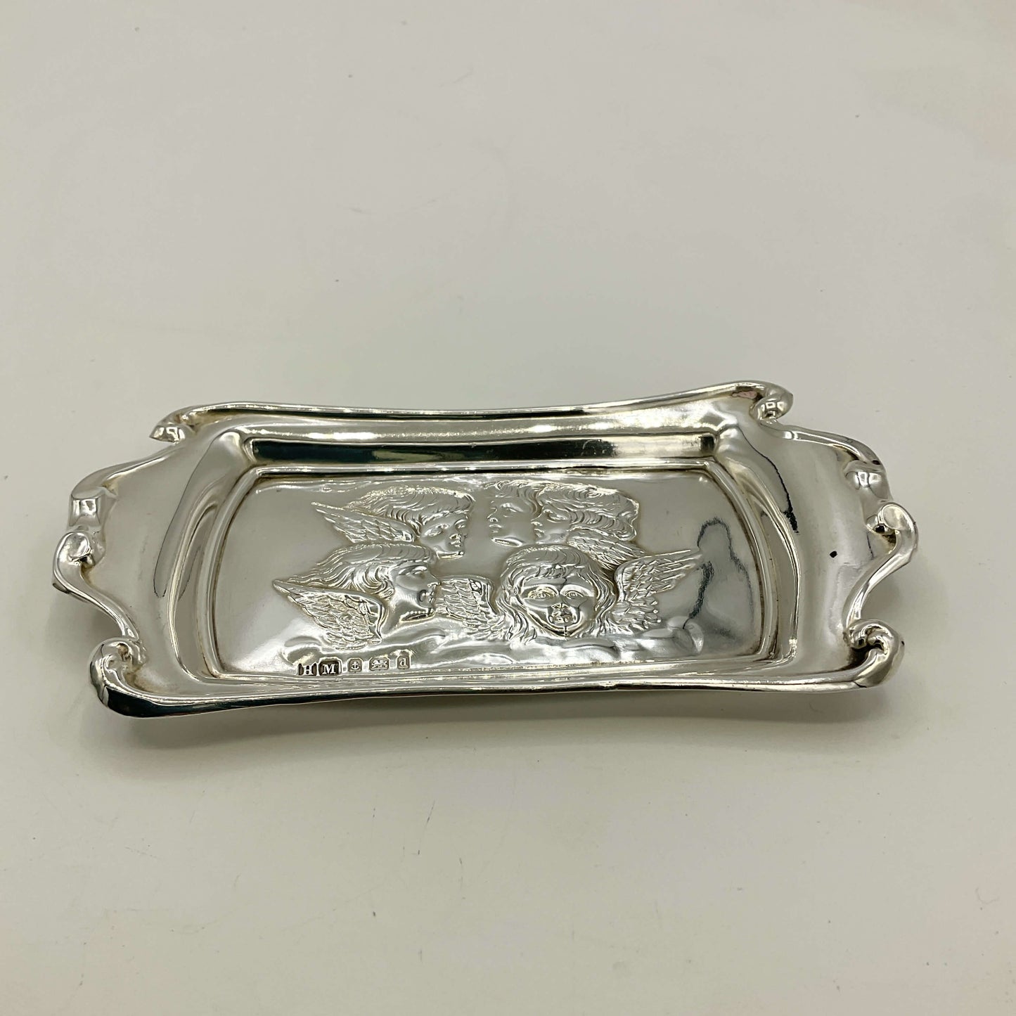 Silver tray with engraved design on a white background