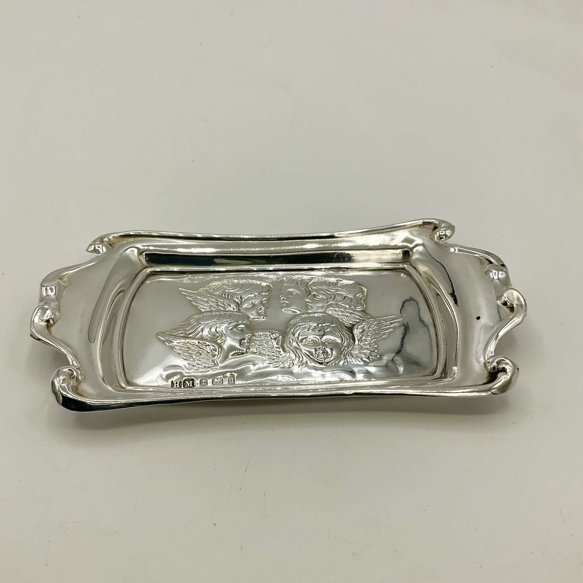 Silver tray with engraved design on a white background