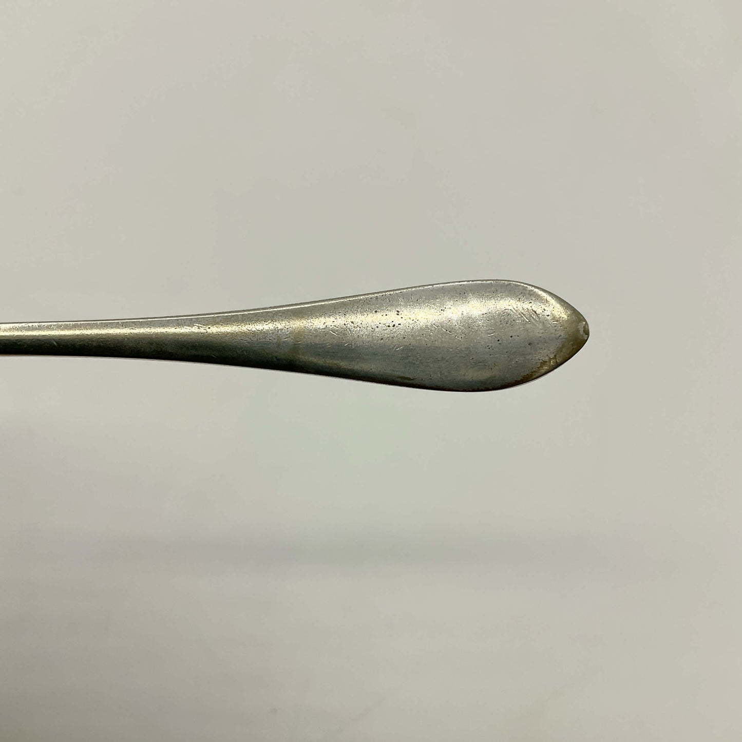 Close-up of a silver plated butter knife on a light gray background