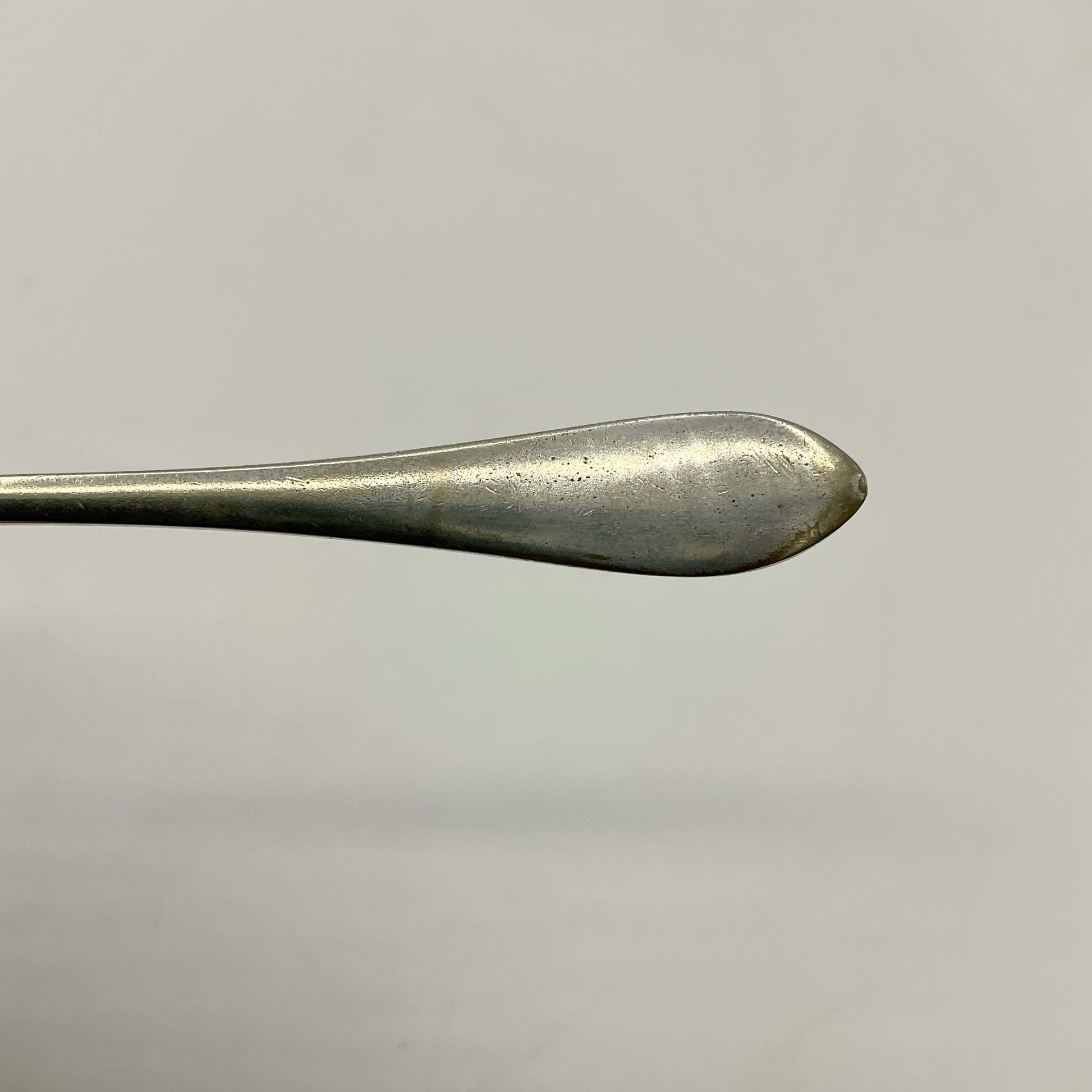 Close-up of a silver plated butter knife on a light gray background