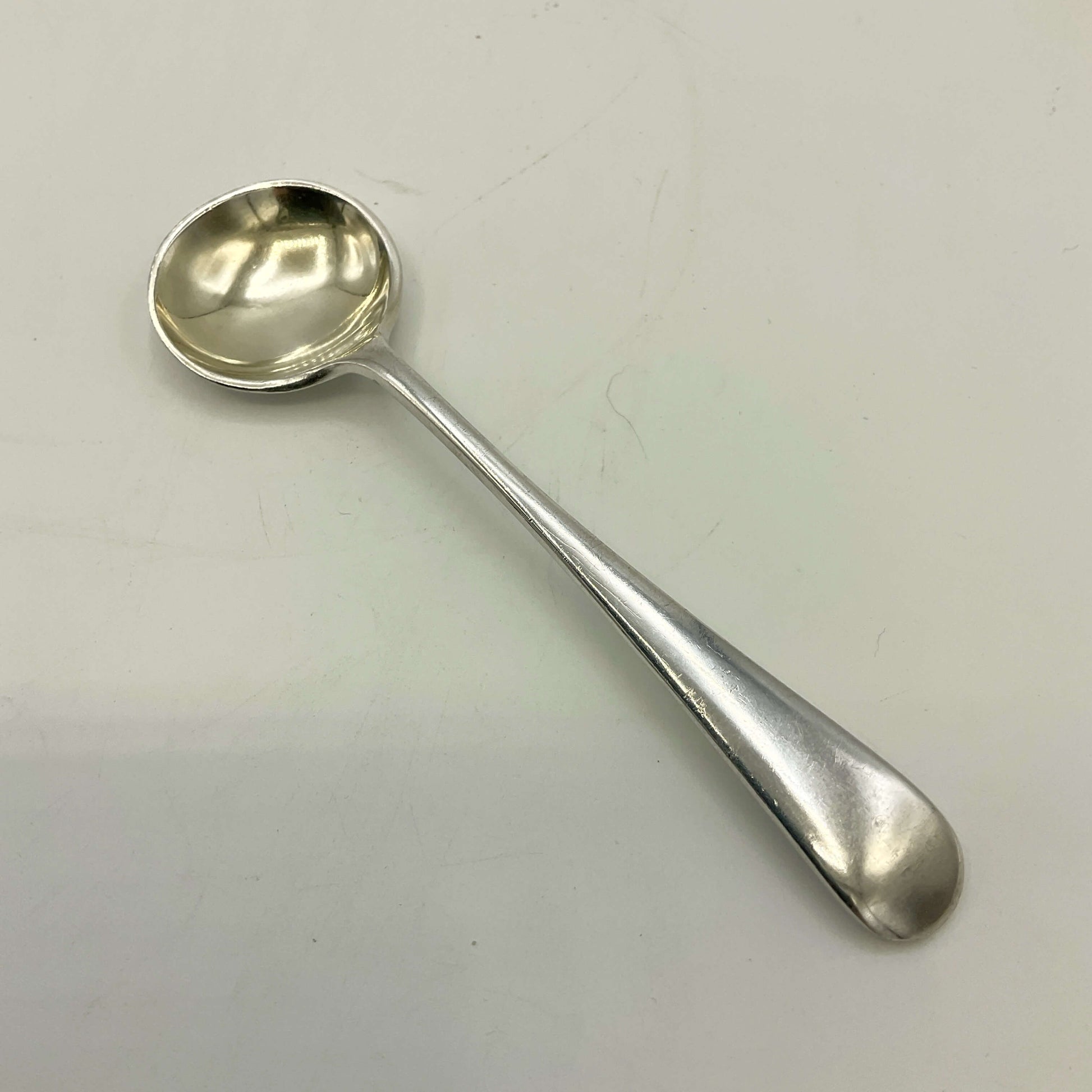Silver spoon on a light grey background