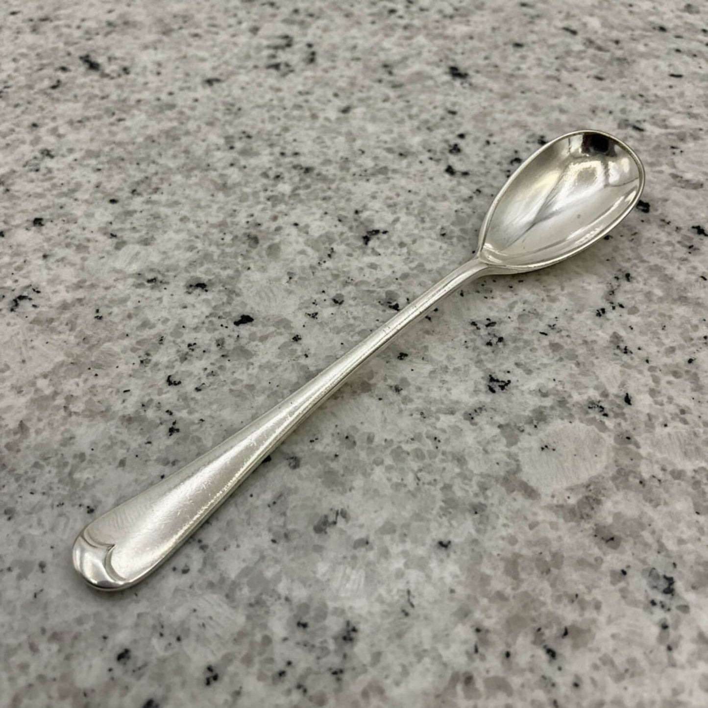 Silver spoon on a gray granite countertop