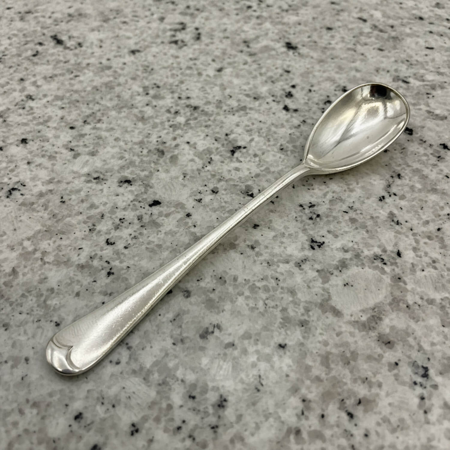 Silver spoon on a gray granite countertop