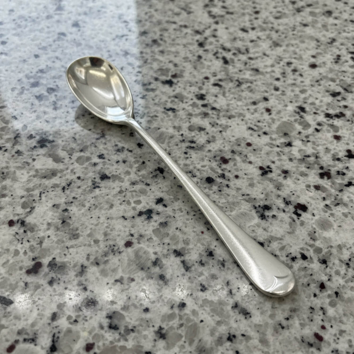 Silver spoon on a speckled gray countertop