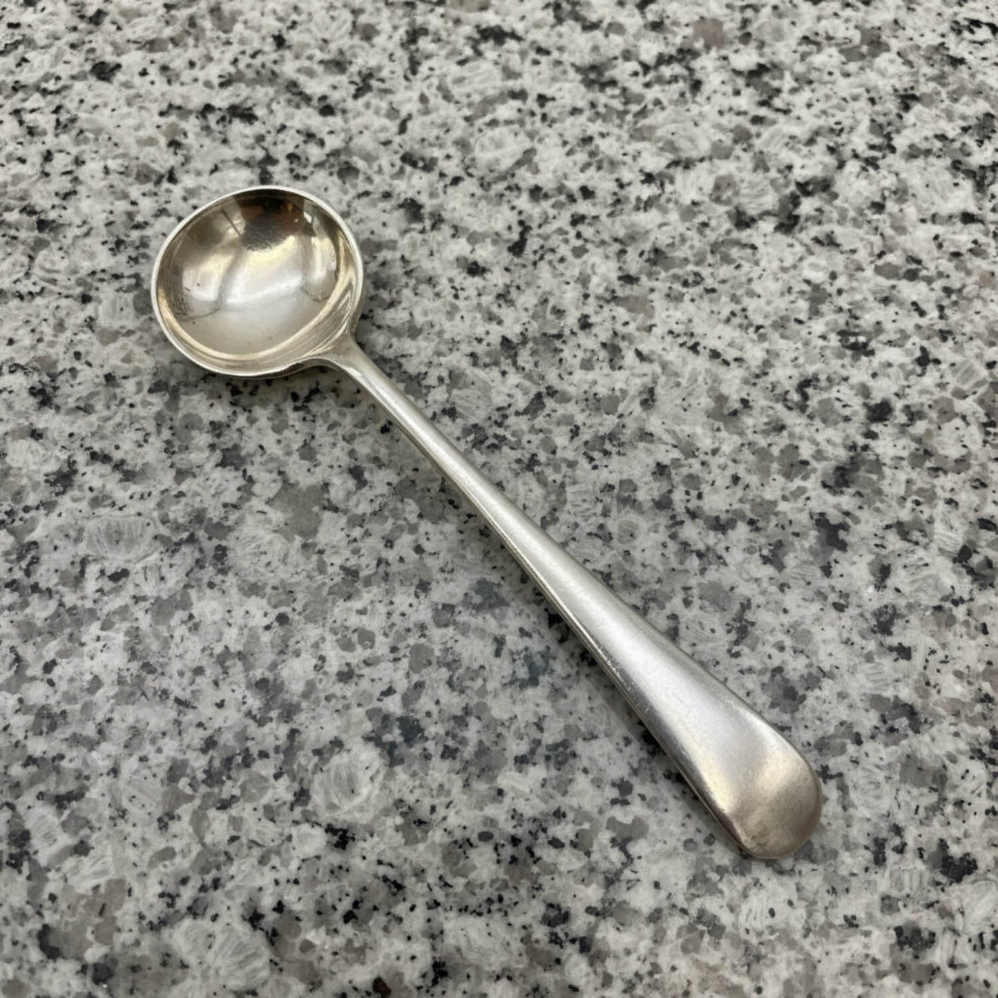 Silver spoon on a grey granite surface