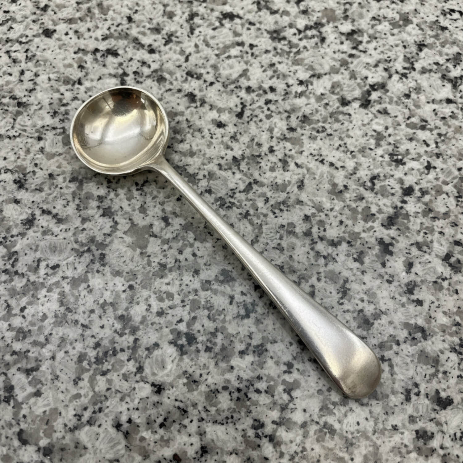 Silver spoon on a grey granite surface
