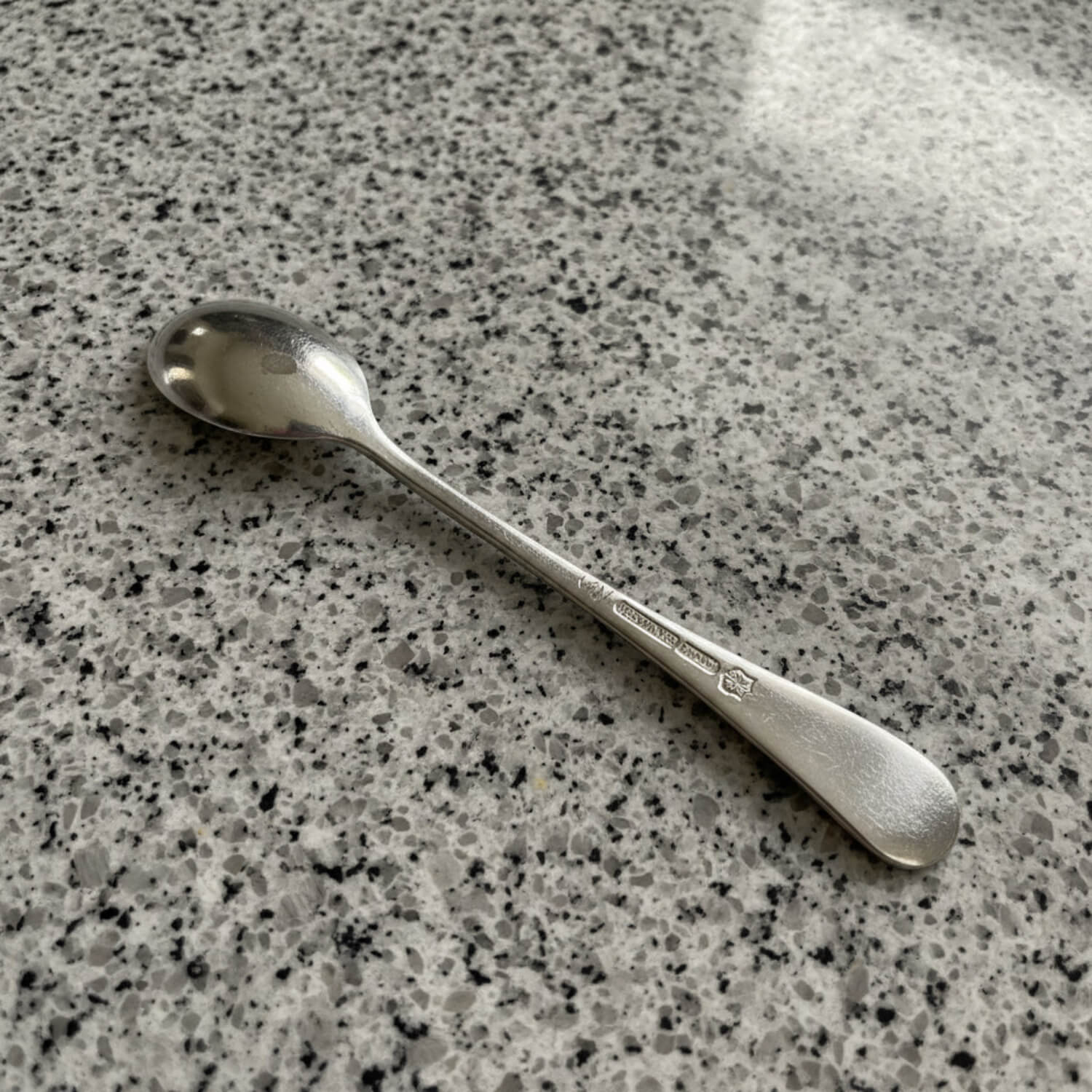 Silver spoon on a speckled gray surface