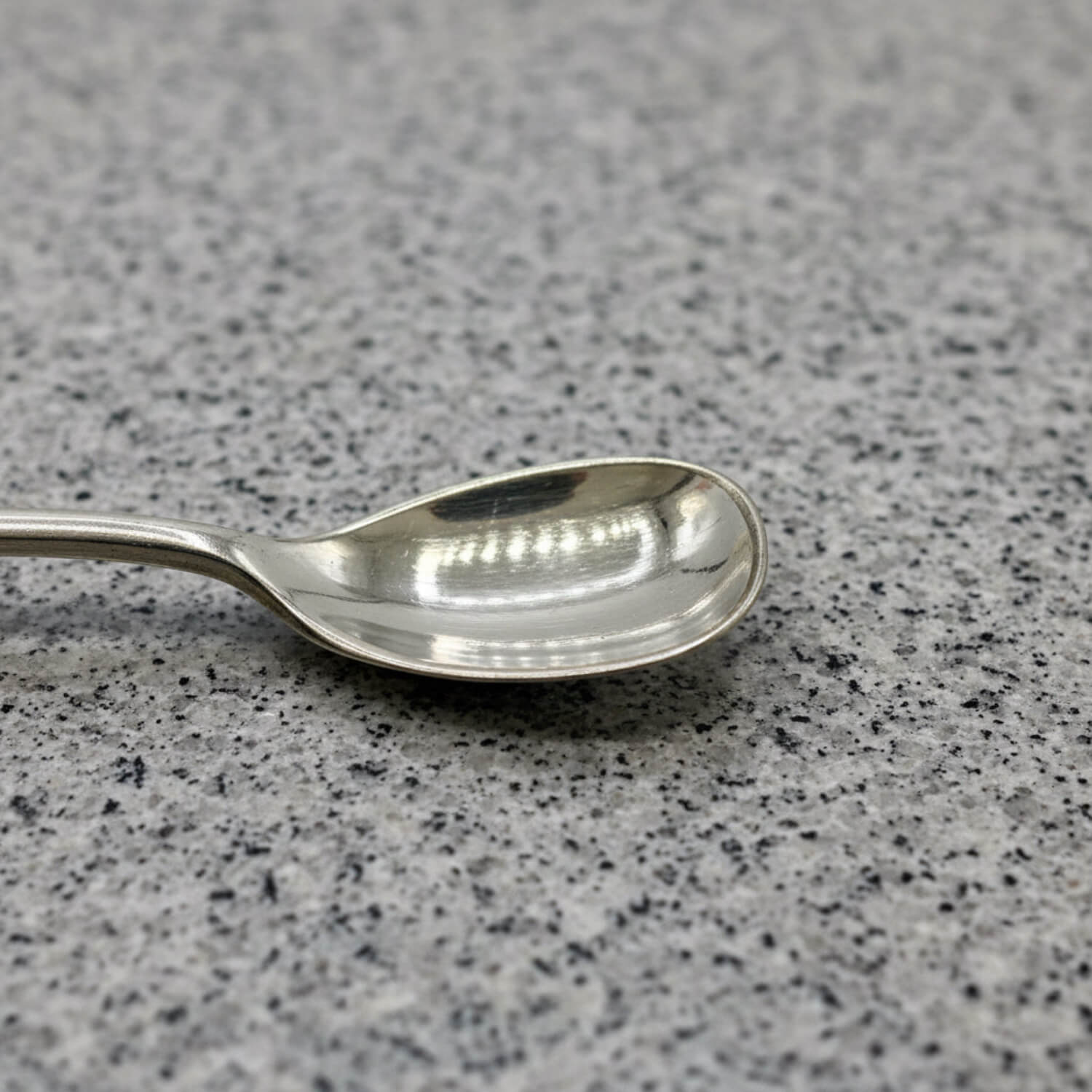 Silver spoon on a grey speckled surface