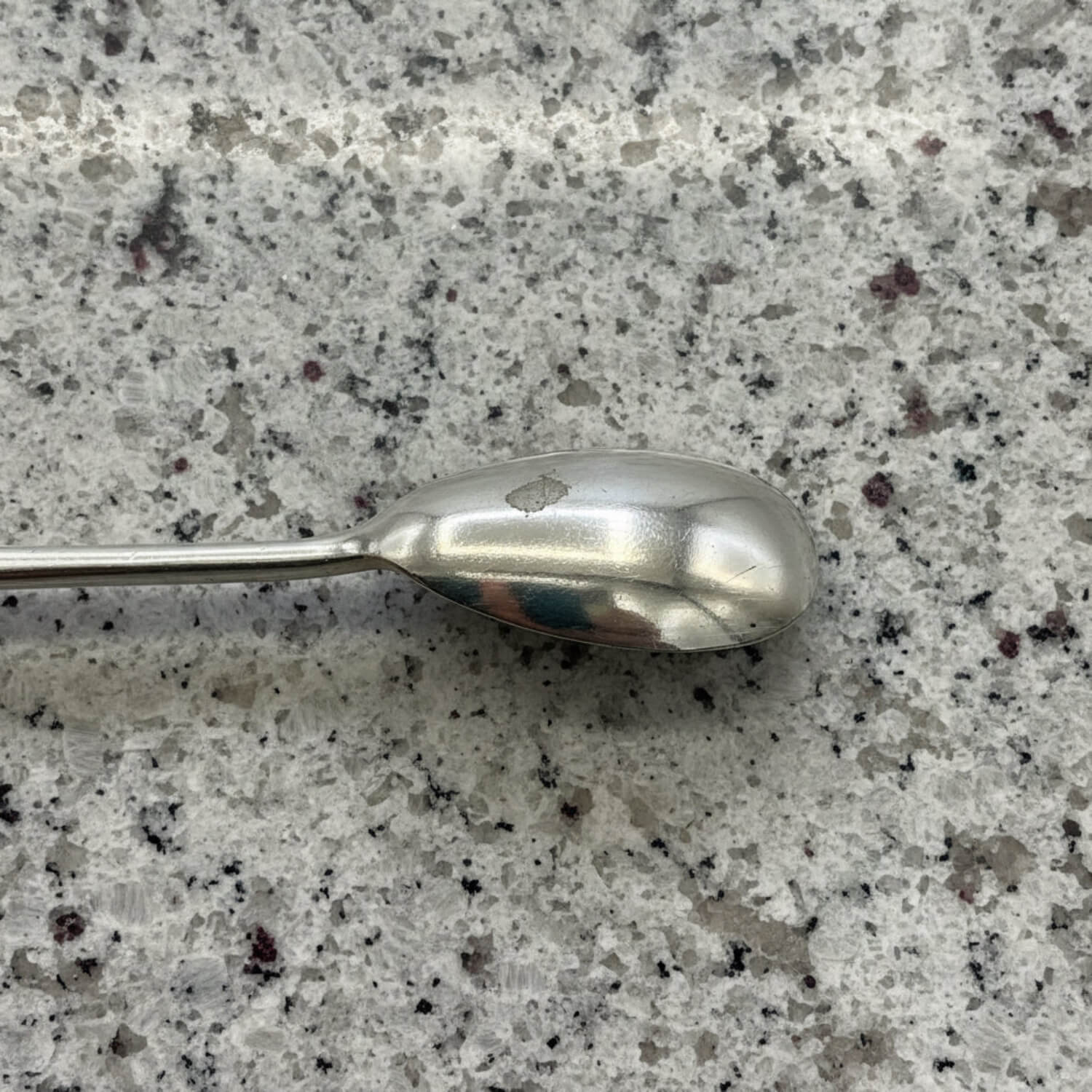 Silver spoon on a speckled grey surface