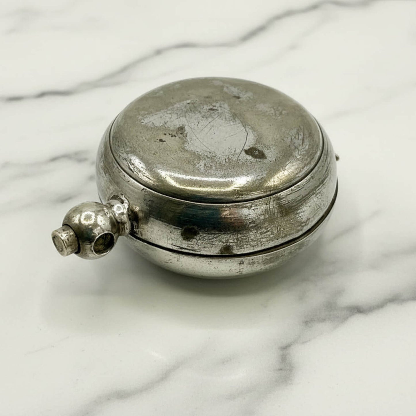 silver plated case with a lid on a marble surface