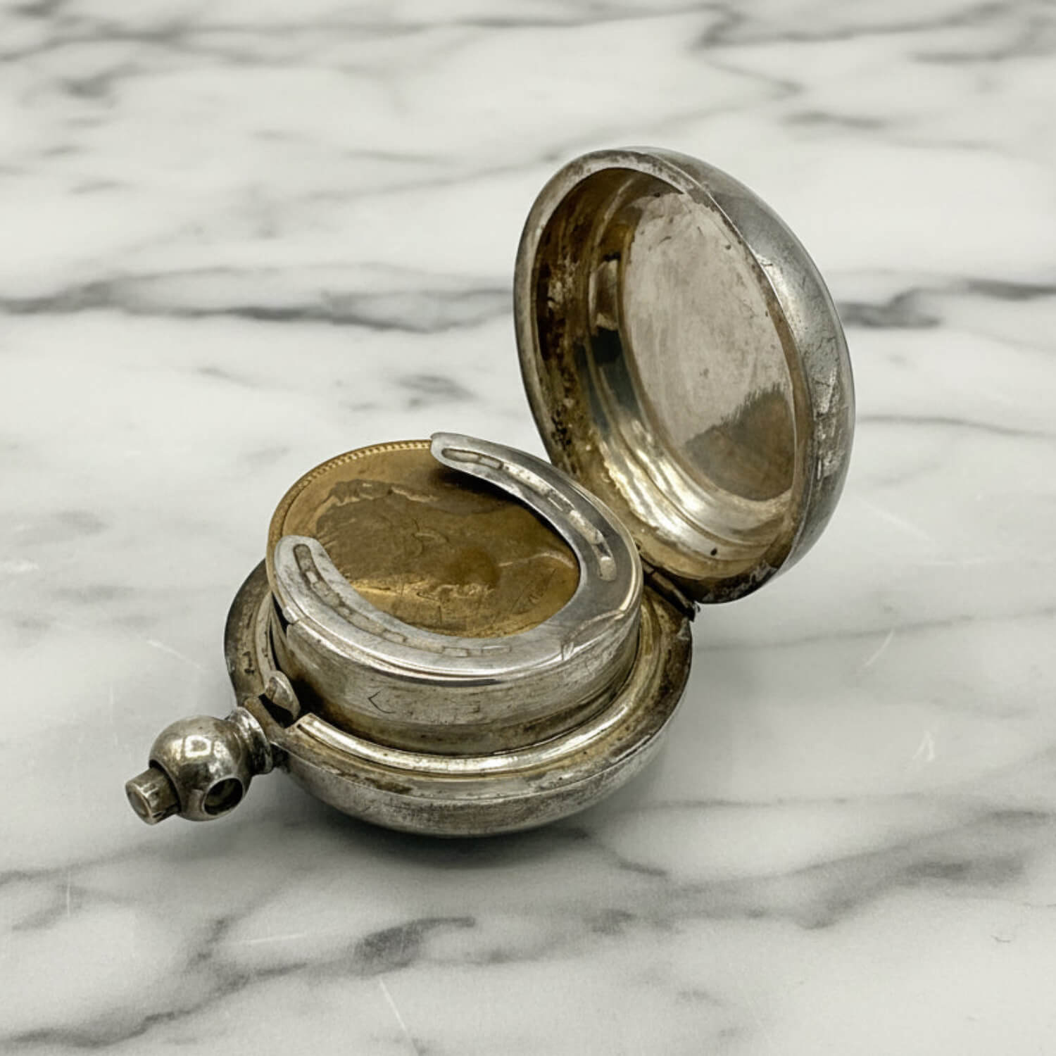 Antique Silver Plated Sovereign Case with the lid open on a marble surface
