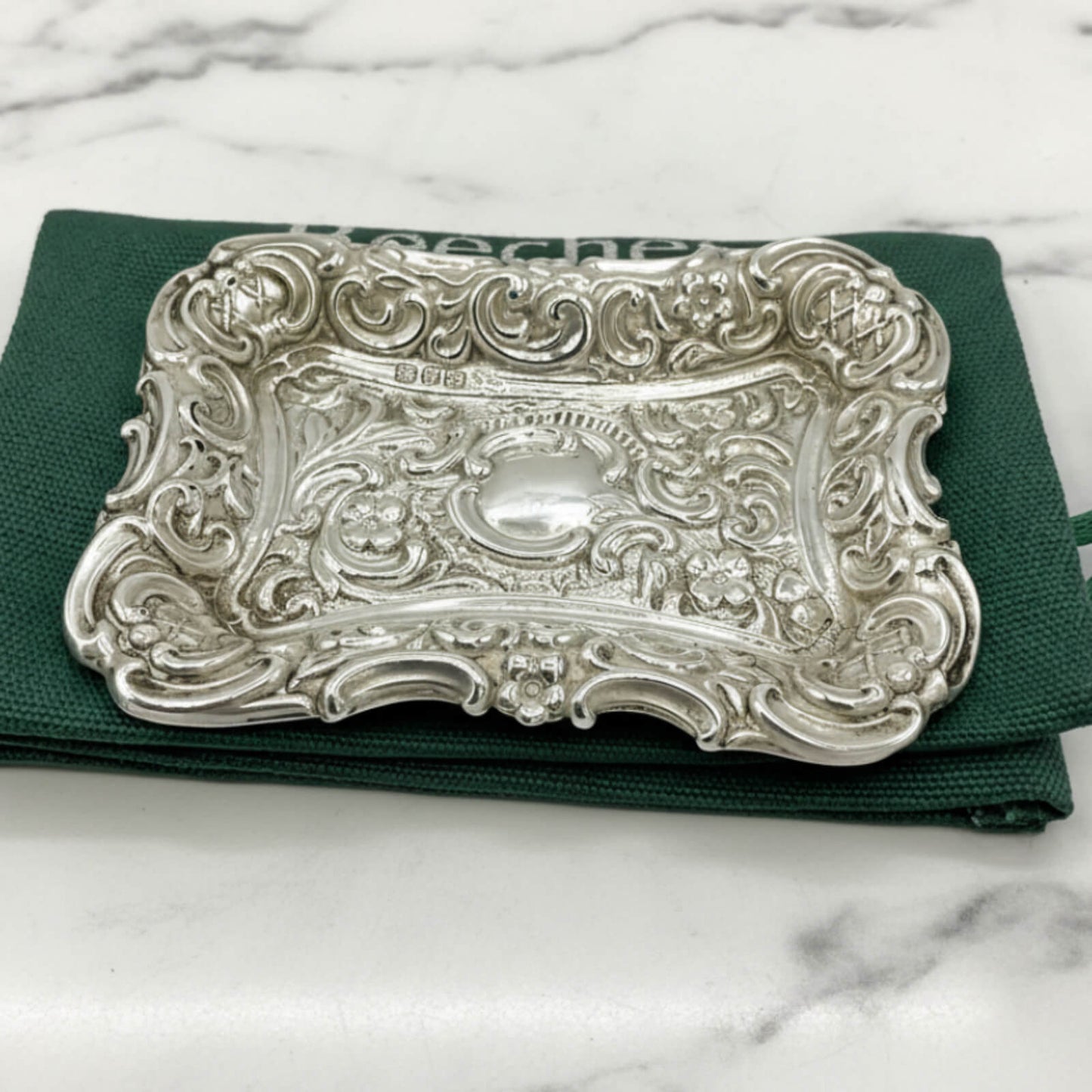 Antique Small Repousse Silver Tray on a  green bag and marble surface