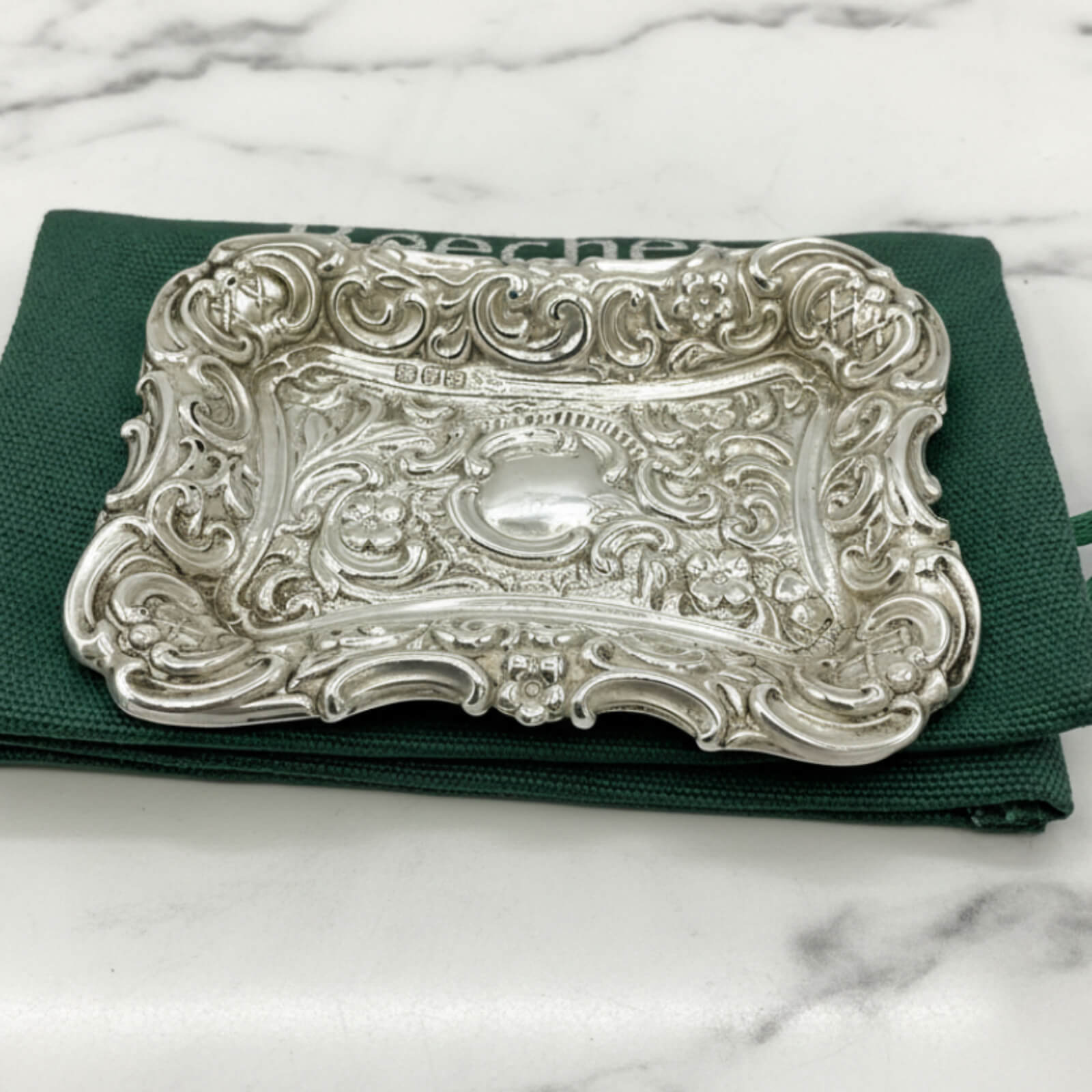 Antique Small Repousse Silver Tray on a  green bag and marble surface