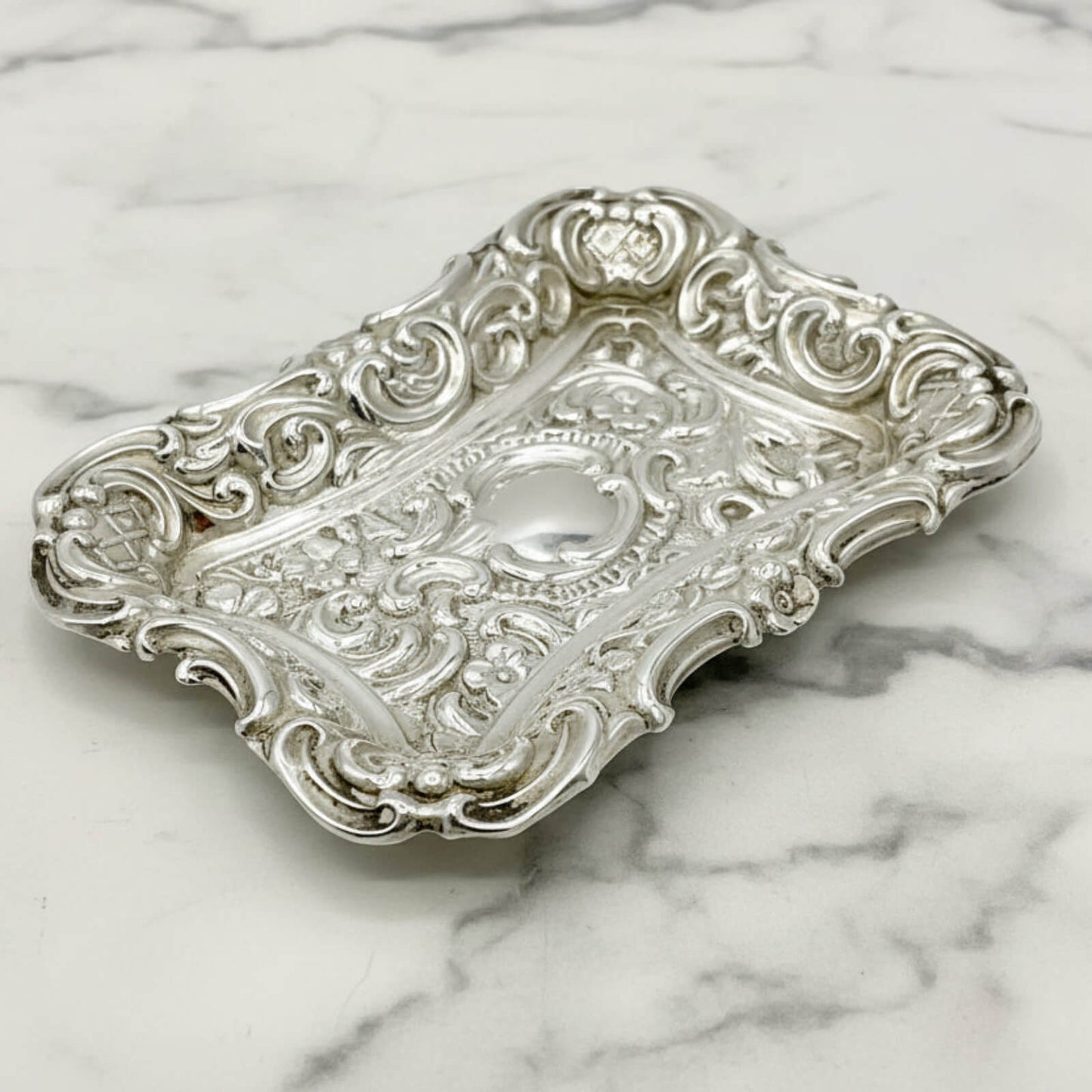 Antique Small Repousse Silver Tray on a marble surface