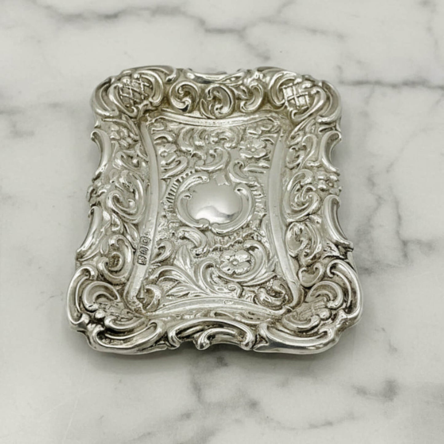 Antique Small Repousse Silver Tray on a marble surface