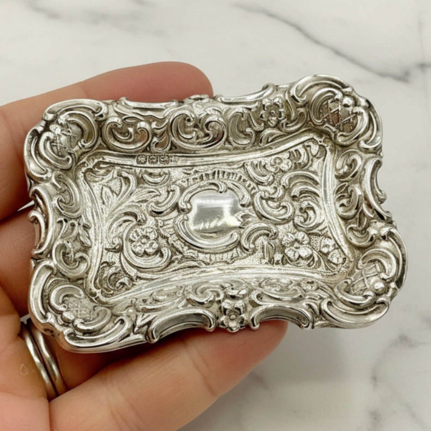 Antique Small Repousse Silver Tray held in a hand