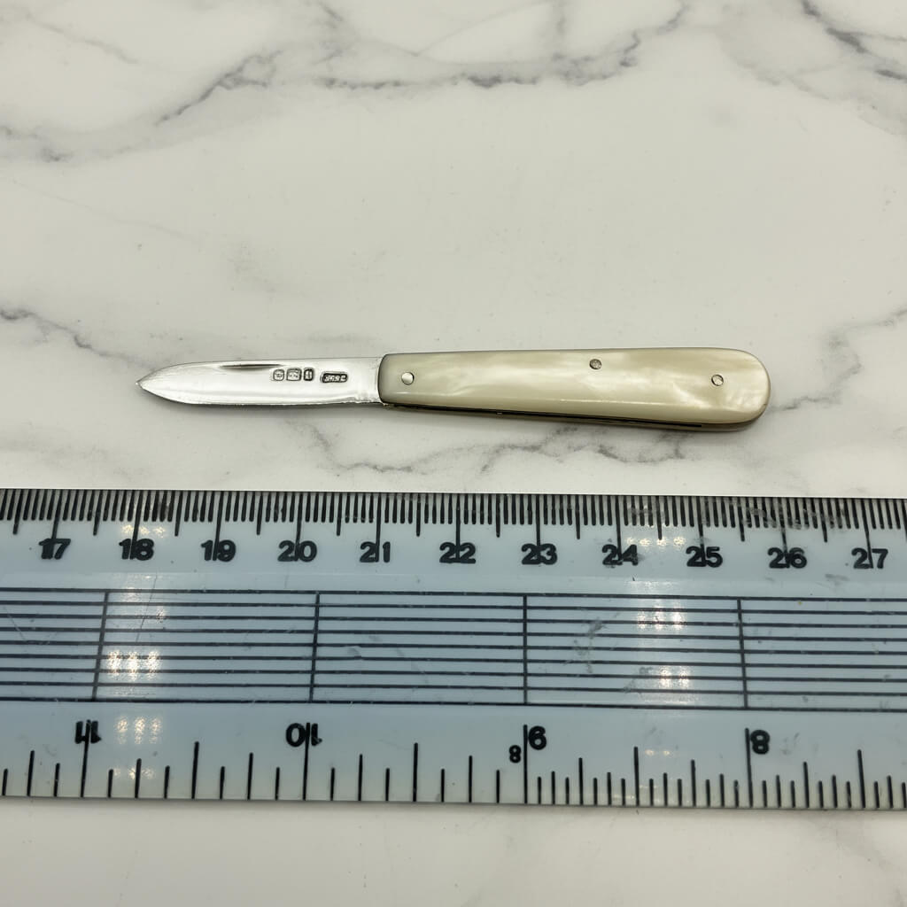 Fruit Knife with a decorative handle on a marble surface next to a ruler for scale.