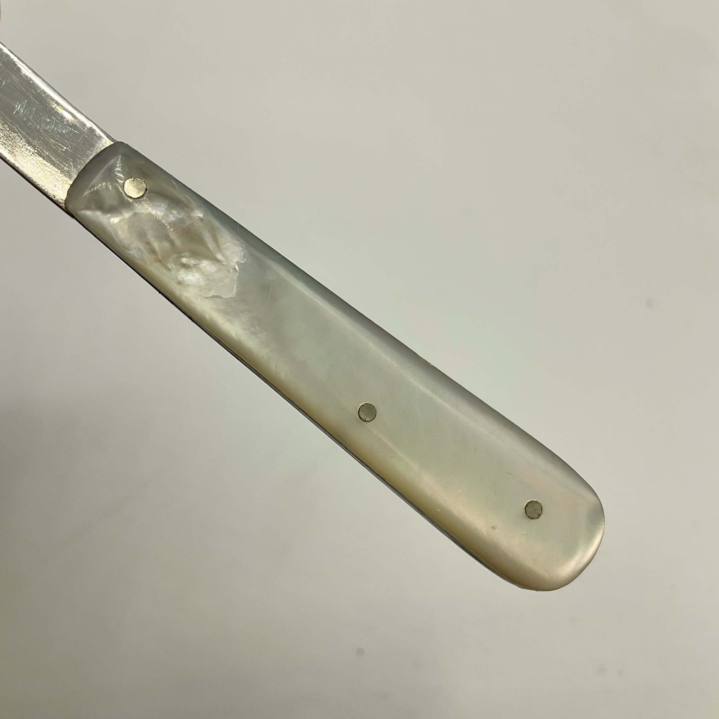 Fruit Knife with a decorative mother of pearl handle on a light gray background