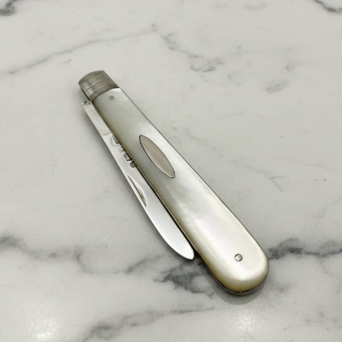Silver fruit knife on a marble surface