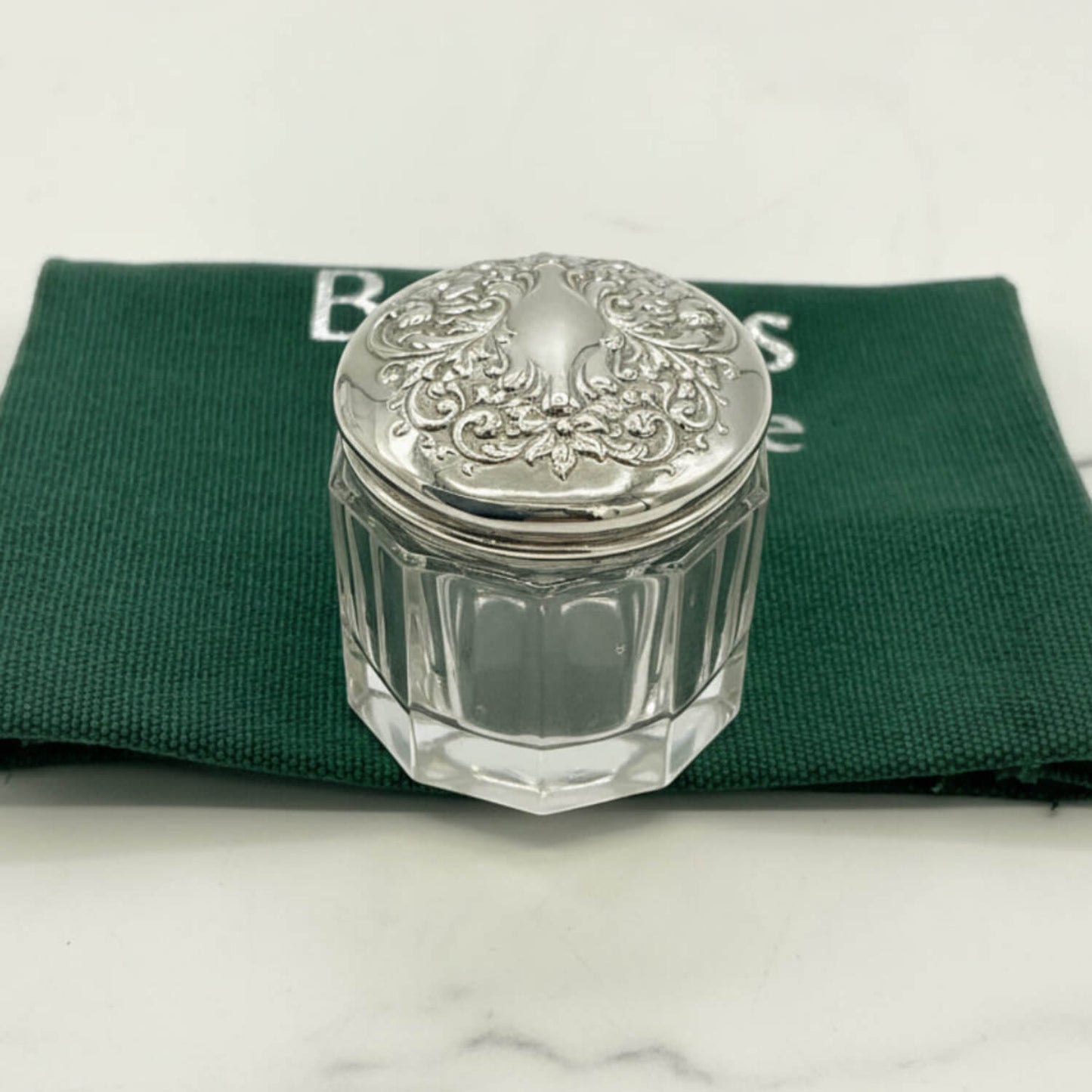 Clear glass jar with silver lid on a green cloth