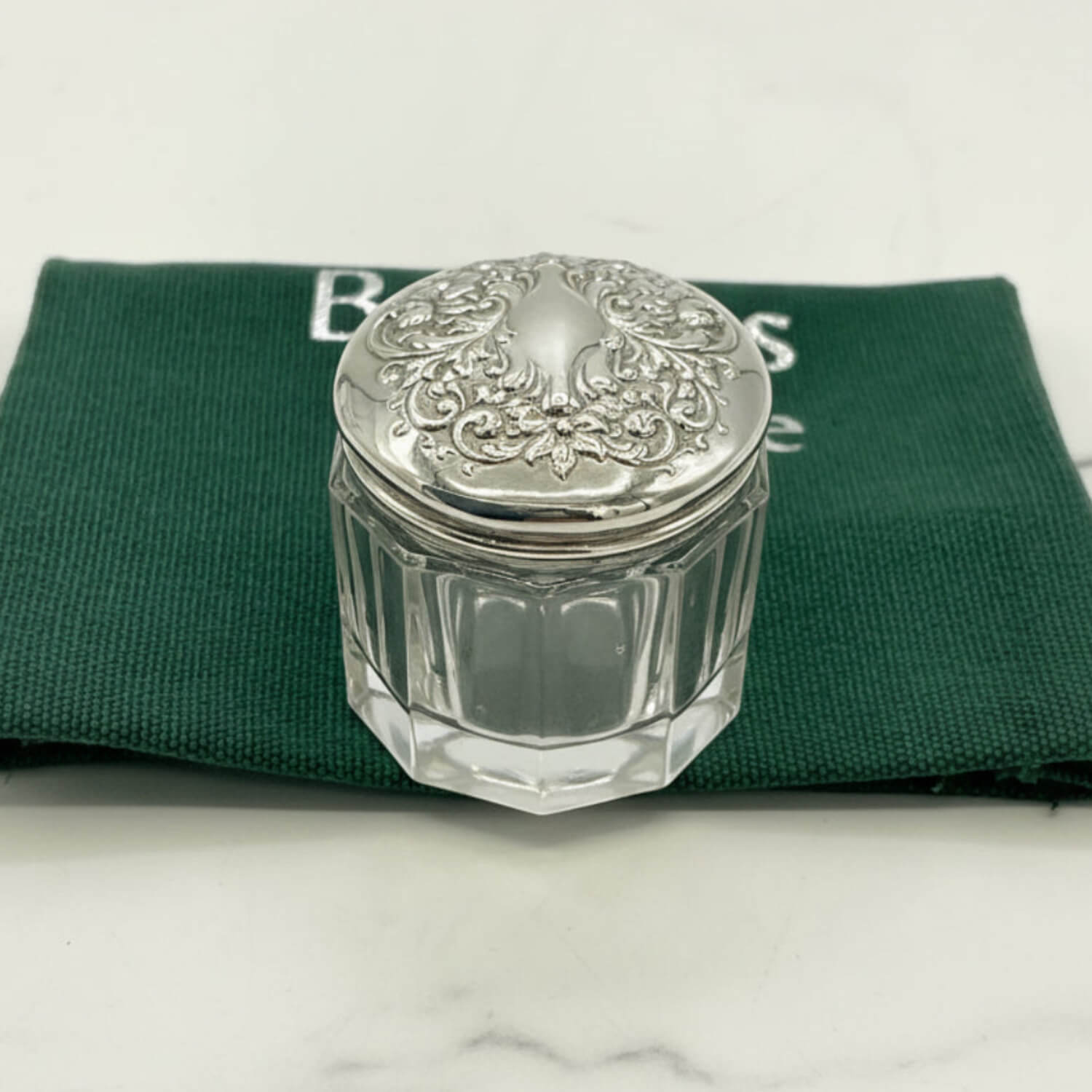 Clear glass jar with silver lid on a green cloth