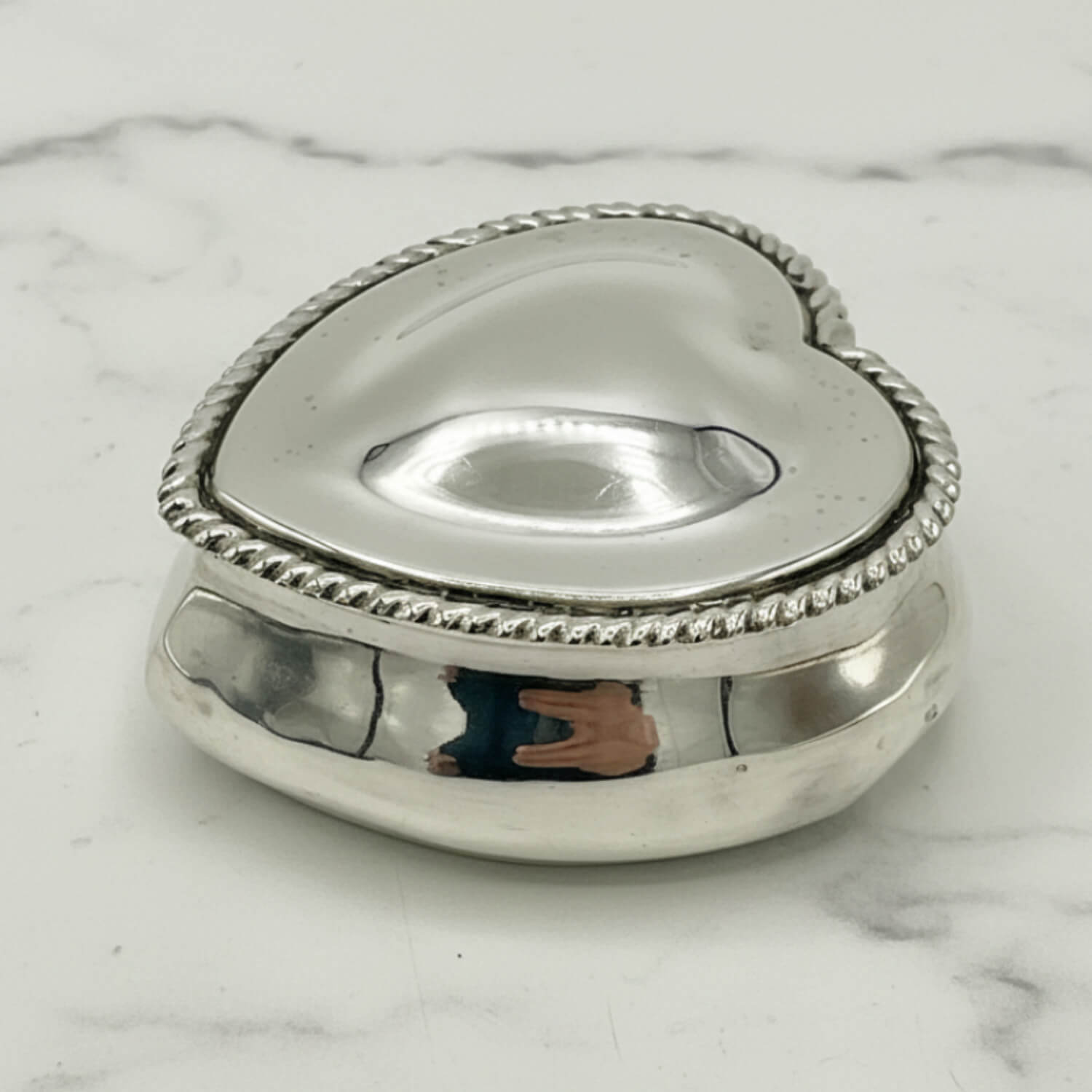 Silver heart-shaped box on a marble surface
