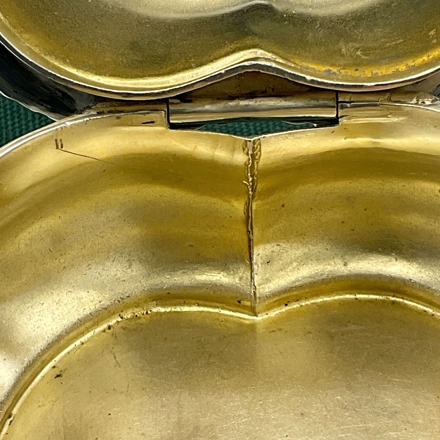 Close-up of a gold nside on box with a green fabric bag background