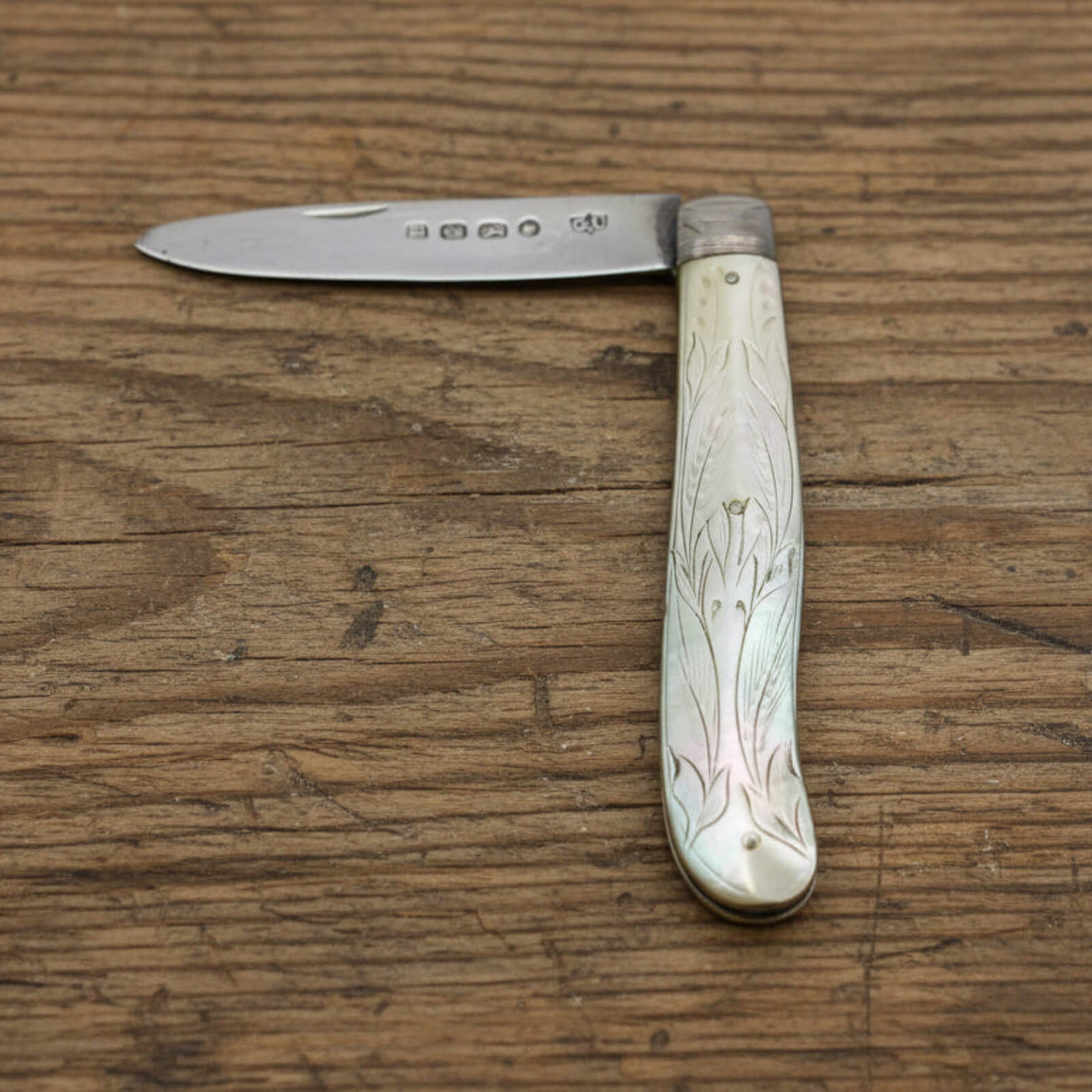 Vintage fruit knife with decorative handle on a wooden surface