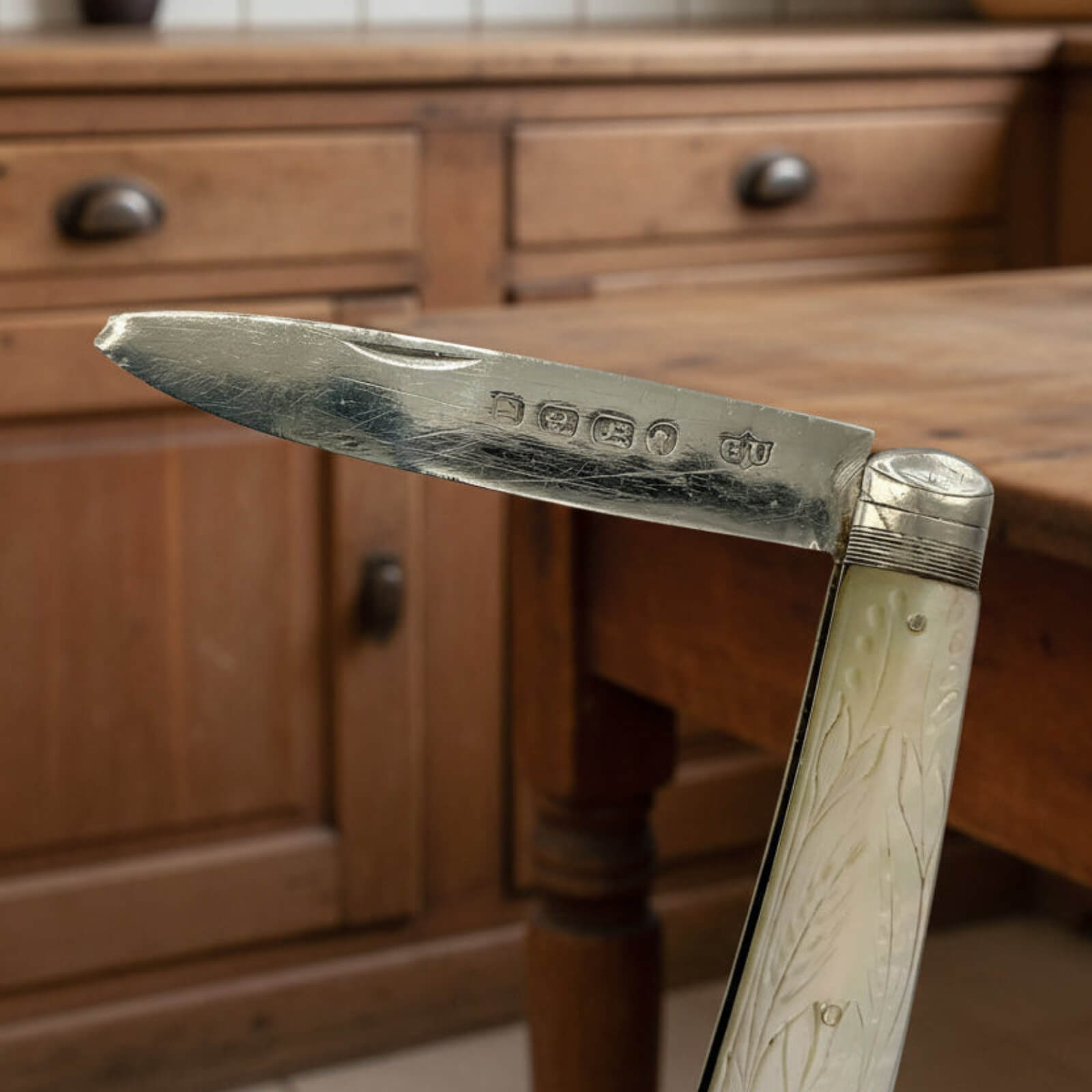 Vintage folding knife with pearl  handle on a wooden surface