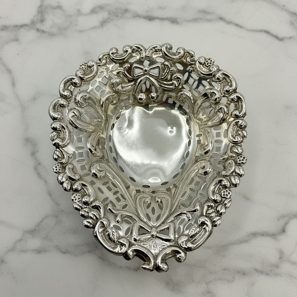 Decorative silver heart-shaped dish on a marble background