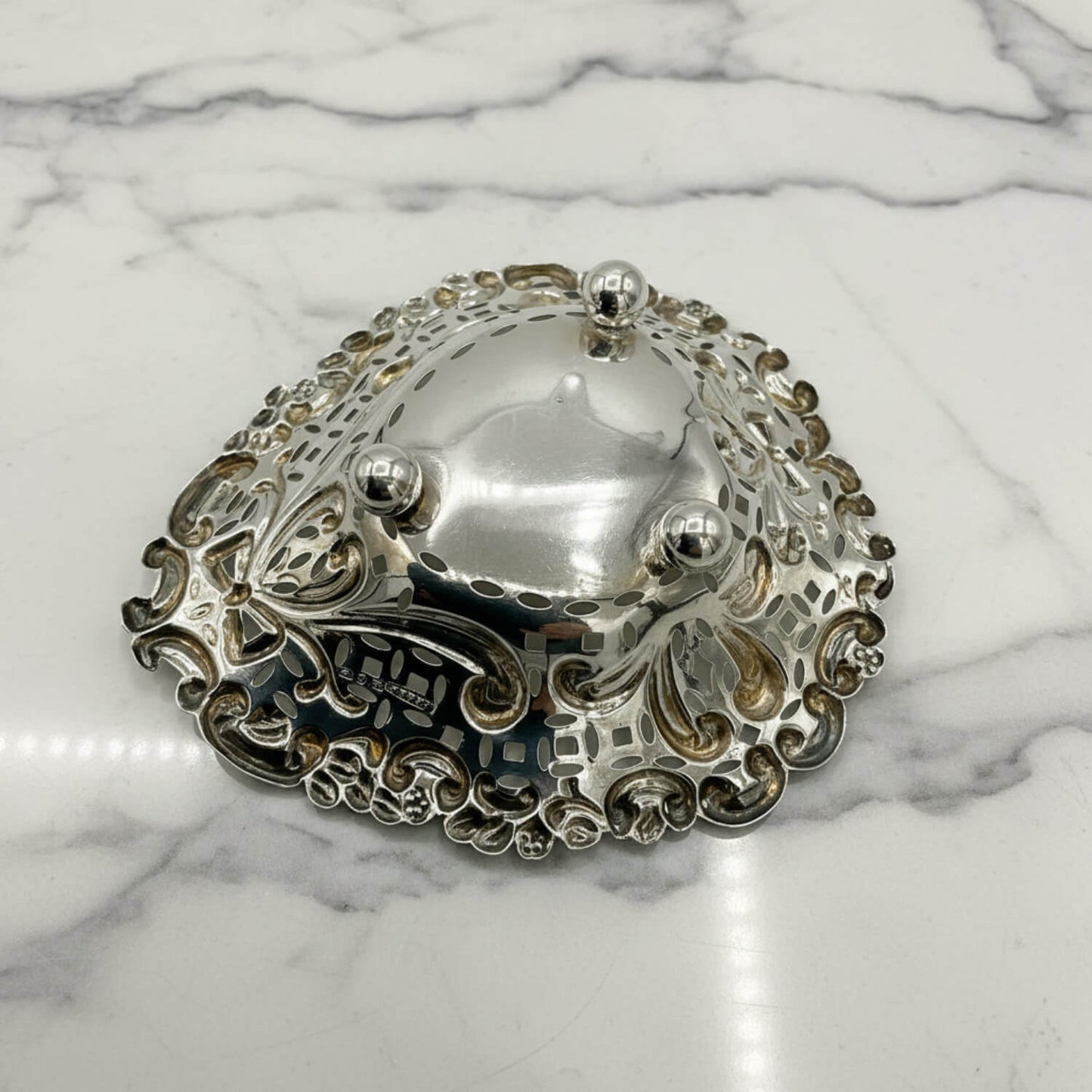 Silver decorative bowl upside down on a marble surface