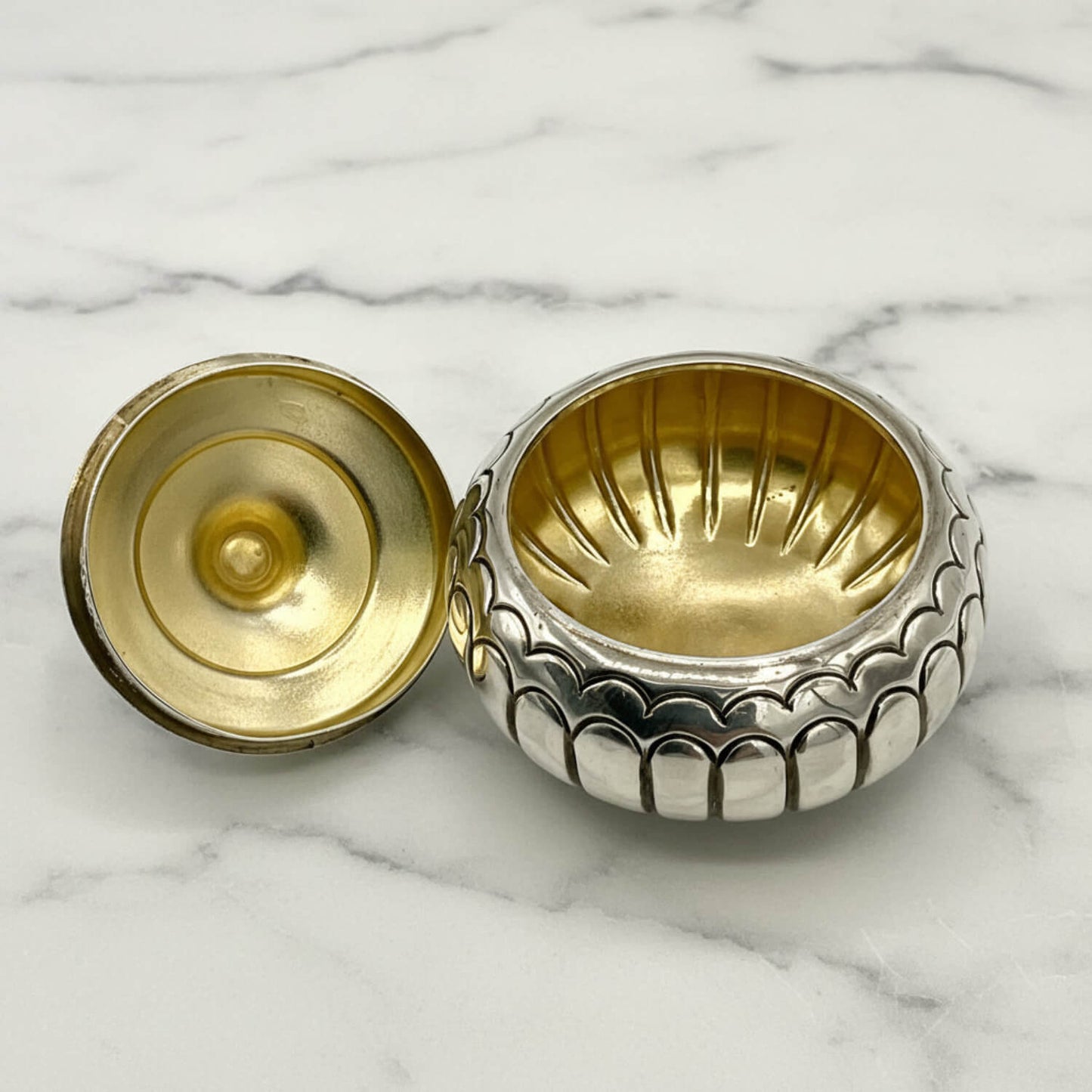 Antique Victorian Sterling Silver Box with a gilded interior on a marble surface